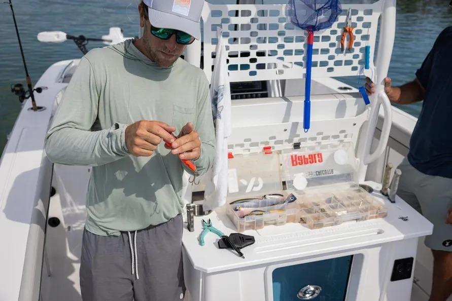 Man preparing fishing gear on 2025 Hurricane Center Console 24 OB boat.