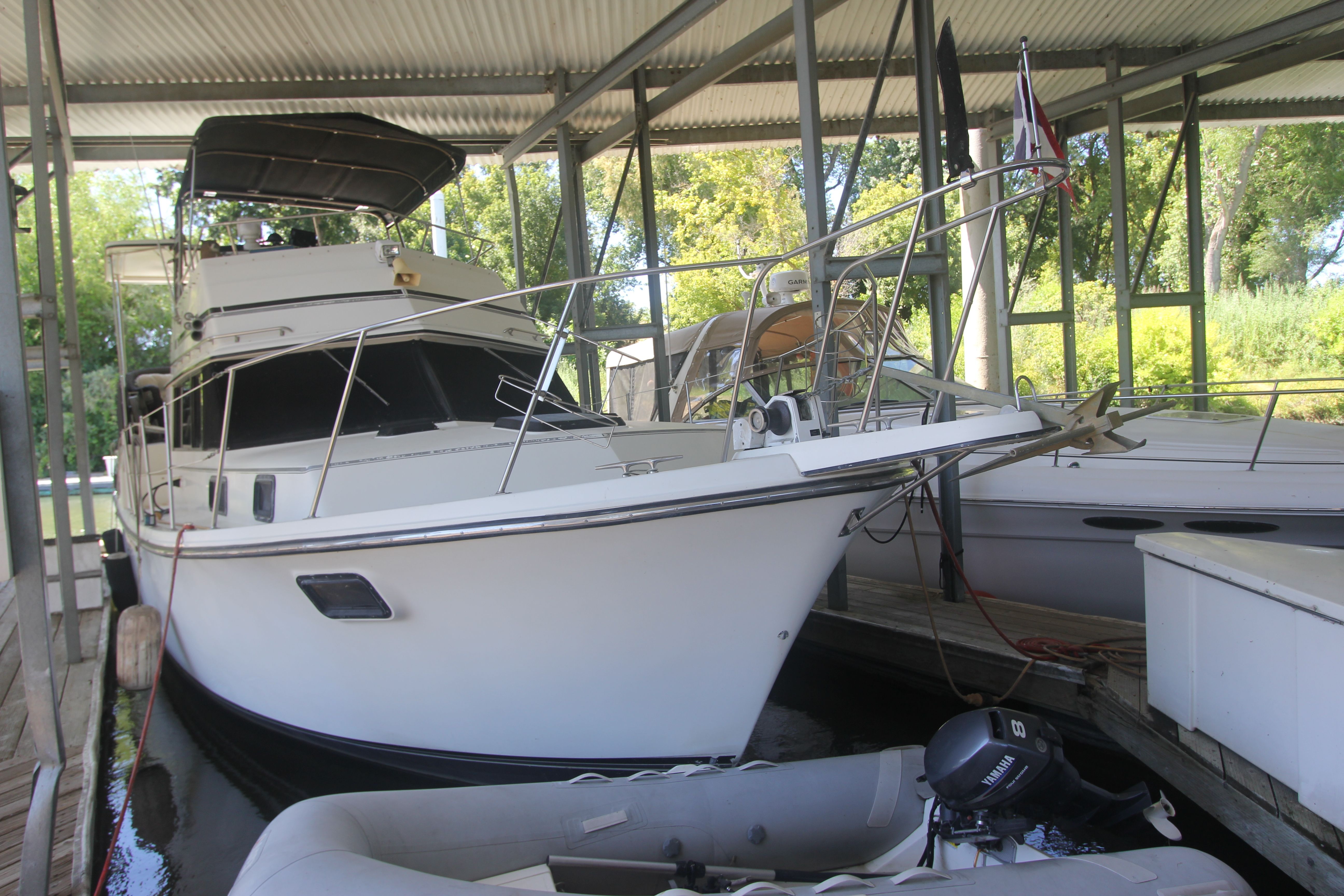 A 1988 Carver 3607 Aft Cabin Motor Yacht docked under a covered shelter.