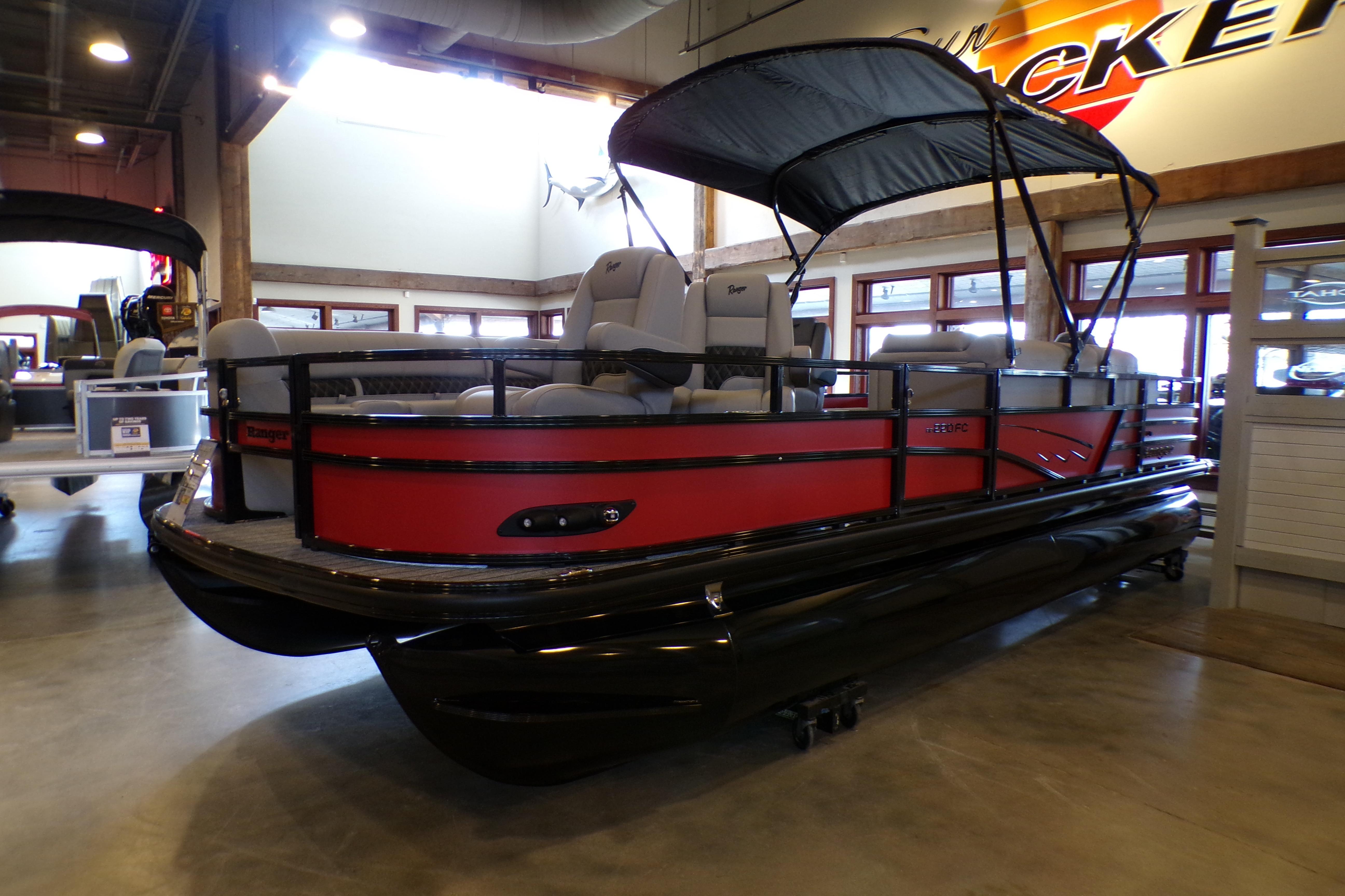 2026 Ranger 220FC pontoon boat with canopy in showroom, featuring sleek red and black design.