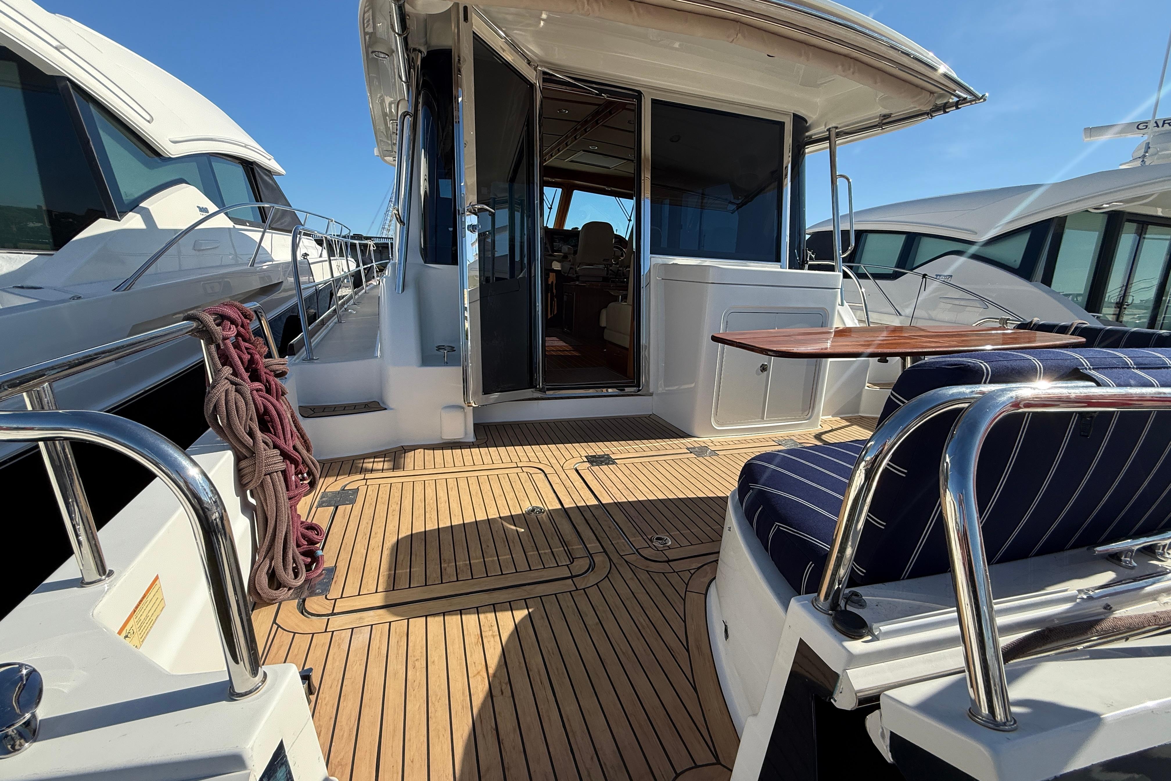 2017 Sabre 48 Salon Express yacht deck with seating and table, docked beside other boats.