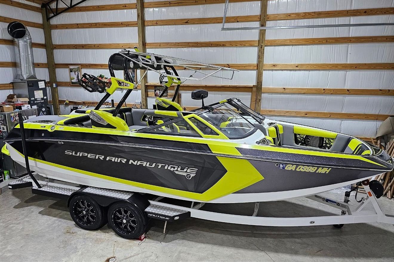 A 2016 Super Air Nautique G23 boat in a storage facility, on a trailer.