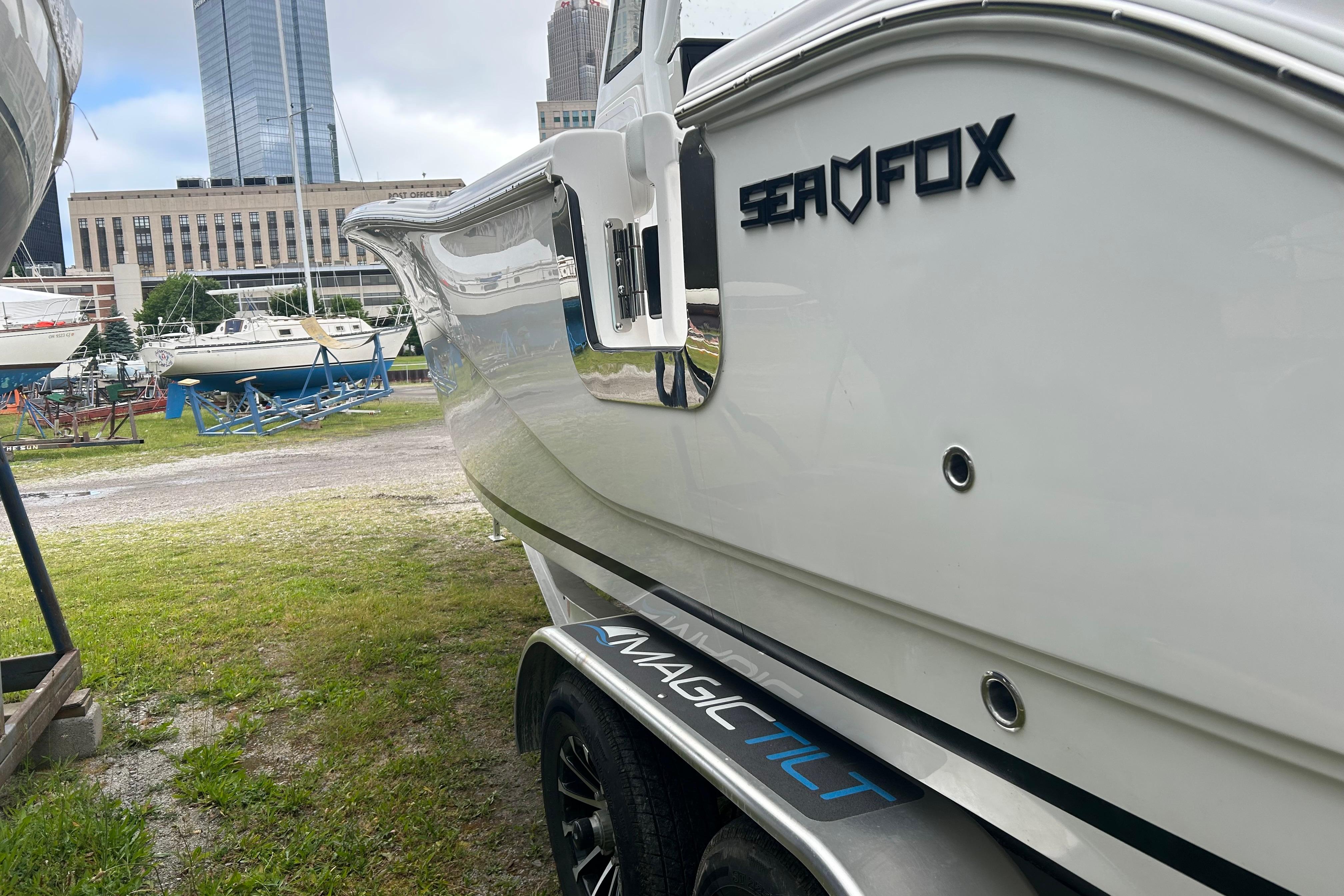 2026 Sea Fox 268 Commander boat on trailer, urban skyline background.