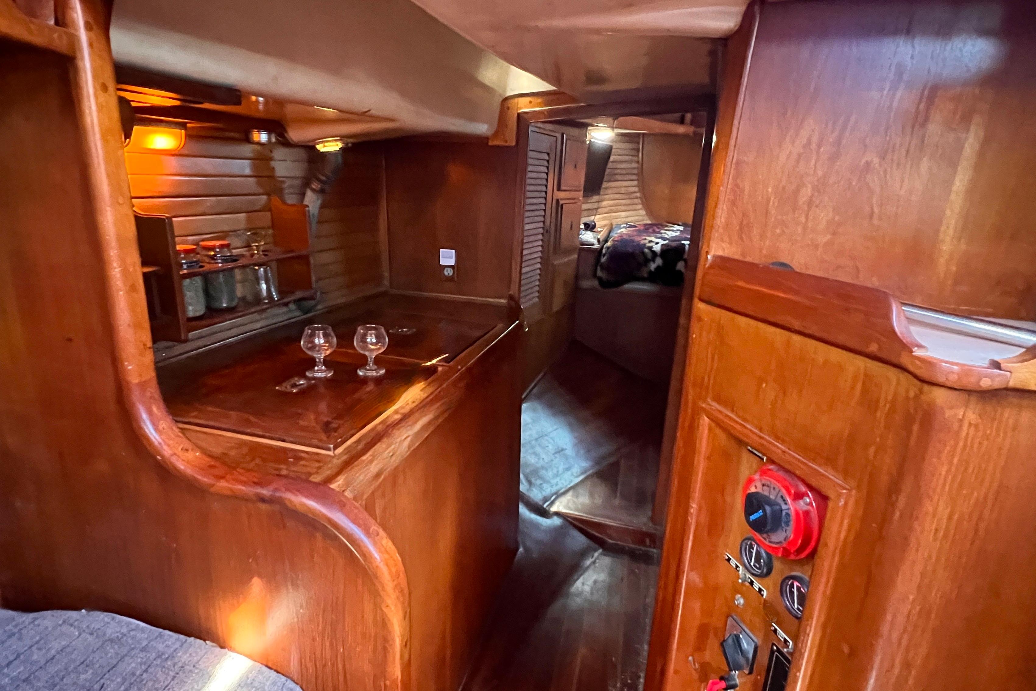 Cozy interior of 1983 Westsail 42 Center Cockpit with wooden finishes and ambient lighting.