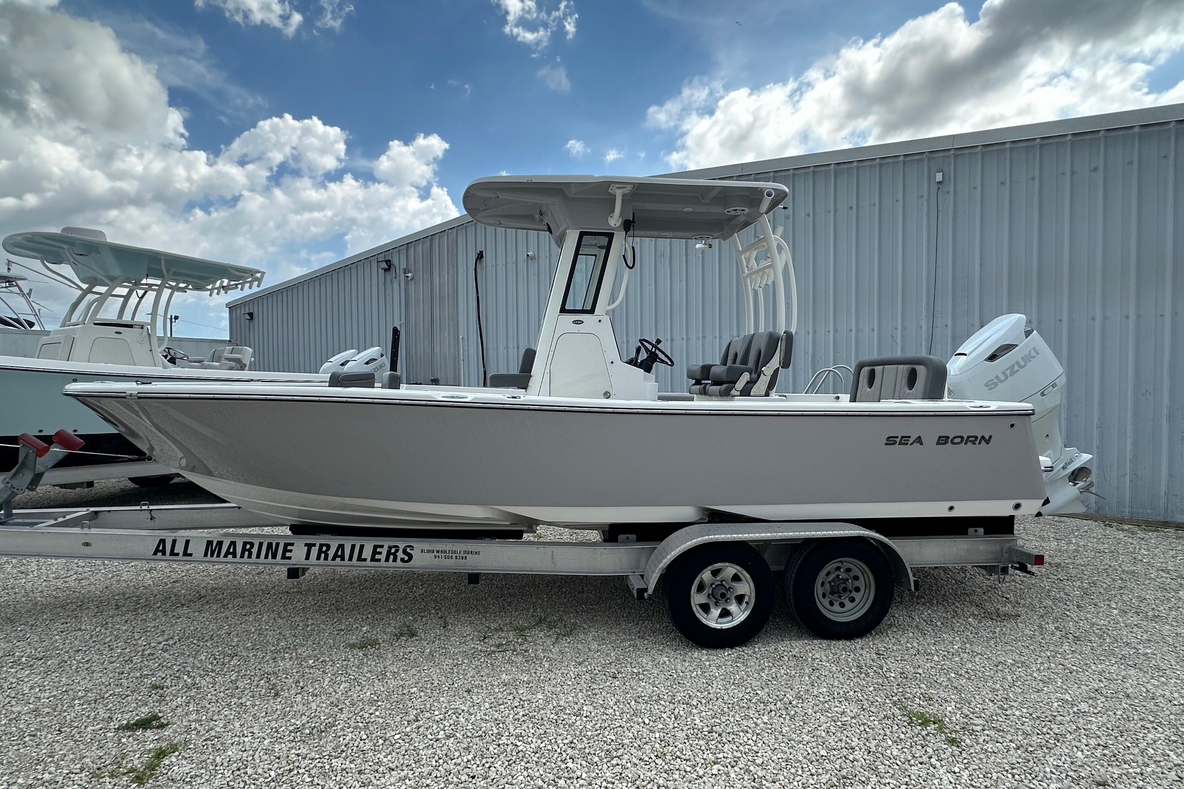 2027 Sea Born LX24 Center Console boat on trailer, parked outdoors under cloudy sky.