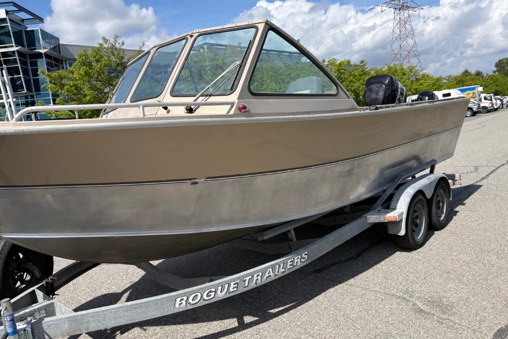 2009 Alumaweld Intruder Outboard 22 boat on Rogue trailer, parked outdoors.