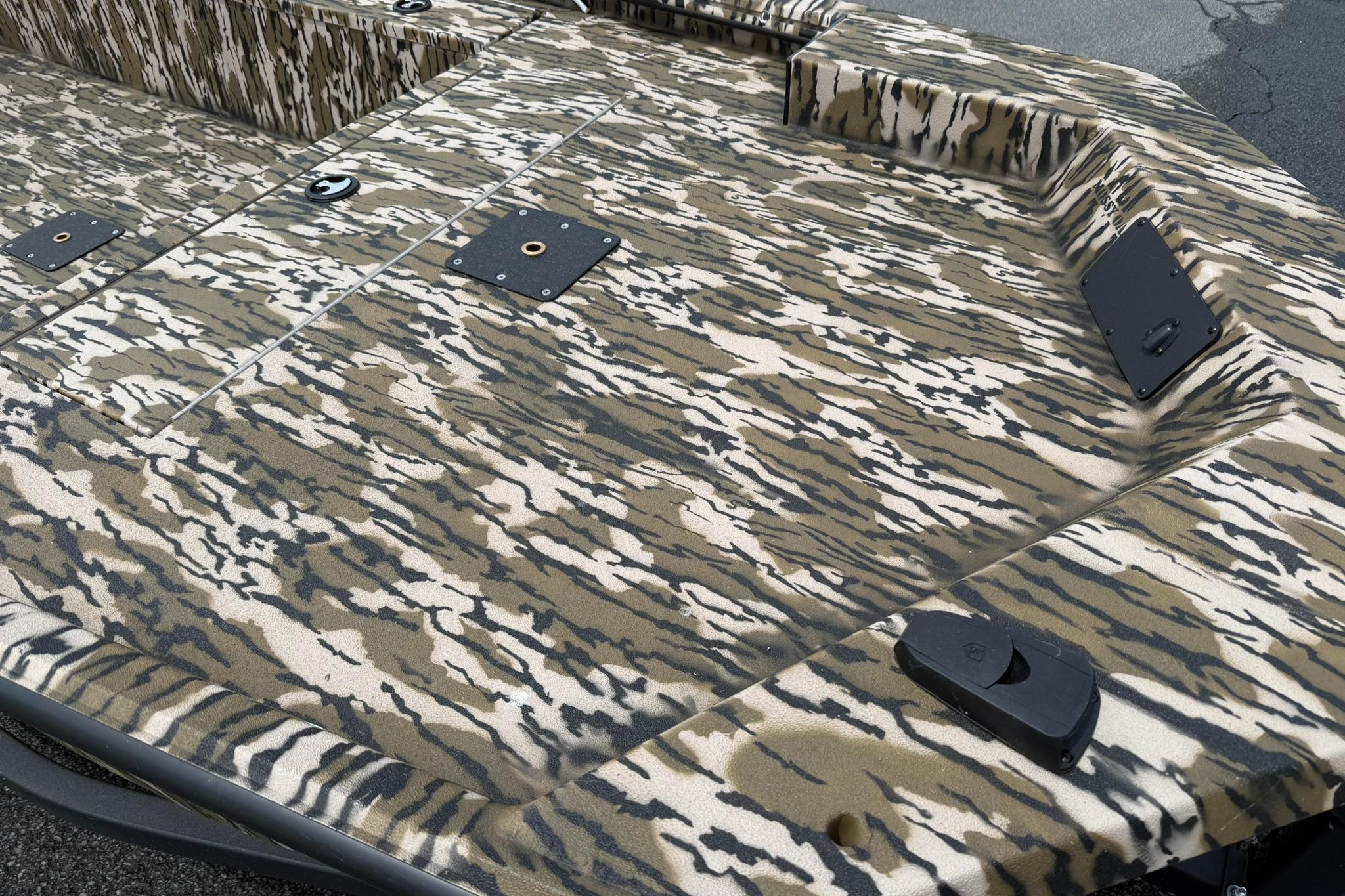 Camouflage-patterned deck of 2026 Avid 16 Commander boat, featuring mounting points and textured surface.
