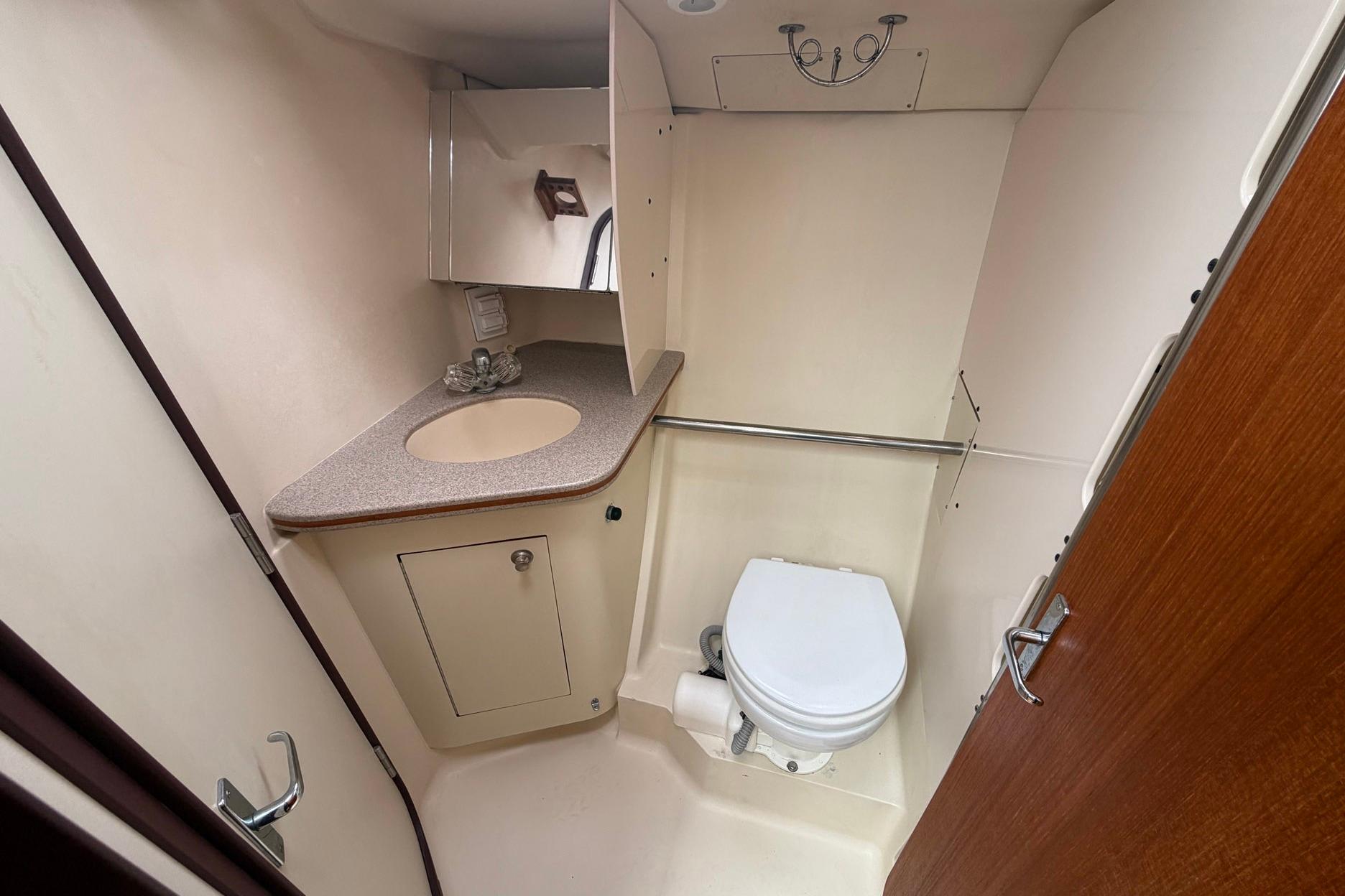 1998 Hunter 410 yacht bathroom with sink, toilet, and storage cabinet.