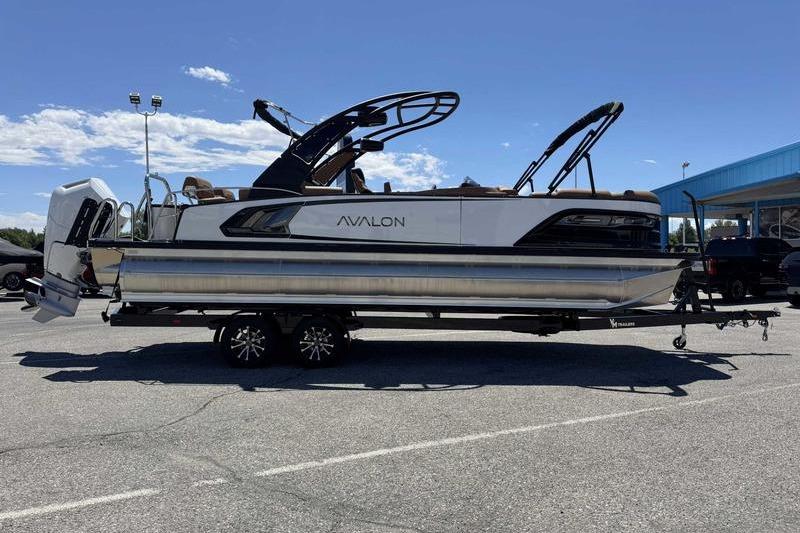 2026 Avalon Excalibur LTD Quad Lounge 27' pontoon boat on trailer, parked outdoors.