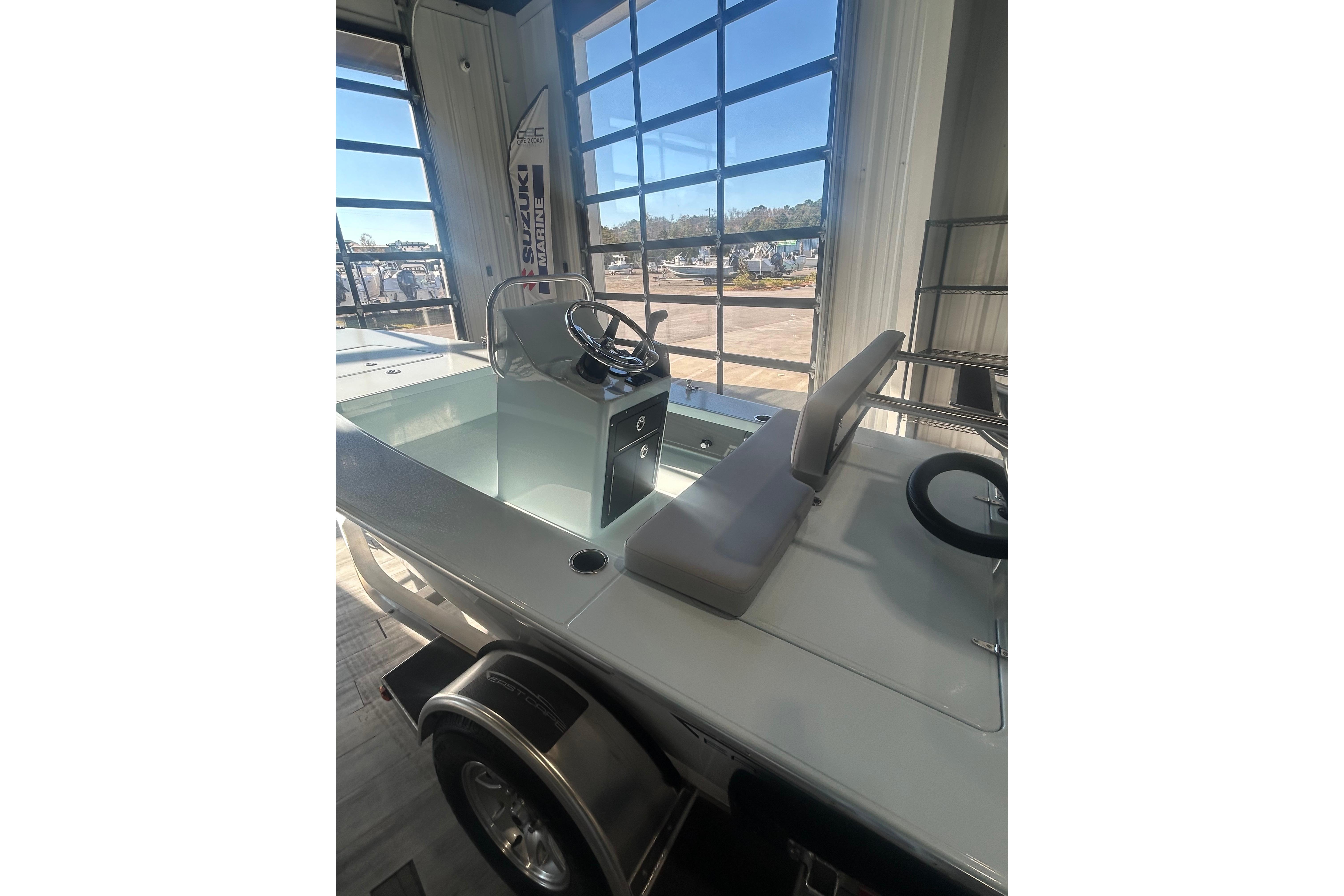 2026 East Cape Evo 17X boat interior with steering console and seating in showroom.