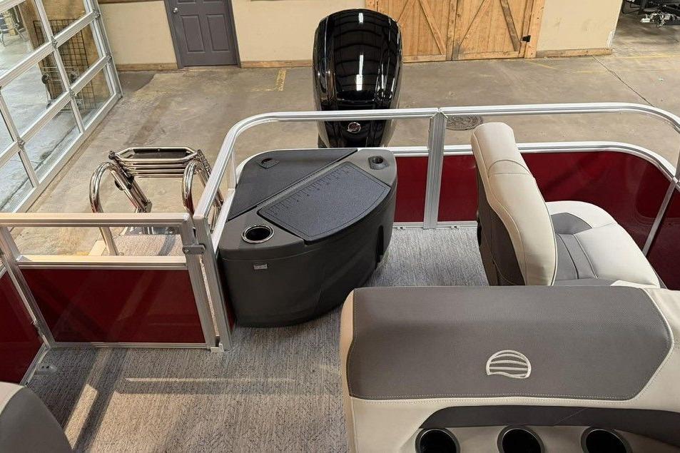 2026 Sun Tracker Bass Buggy 18 DLX interior with seating and motor, in a showroom setting.