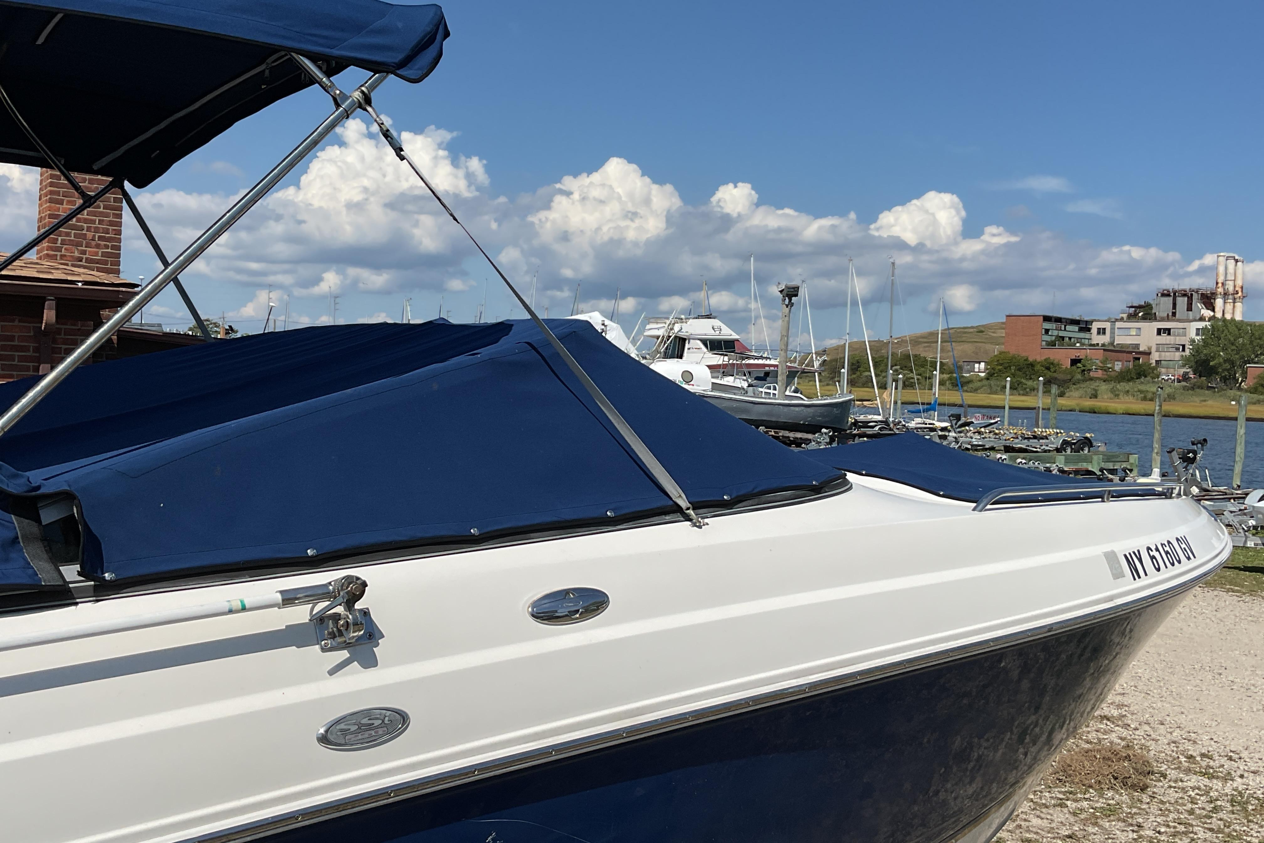 2006 Chaparral 256 SSi boat docked at a marina under a blue sky.