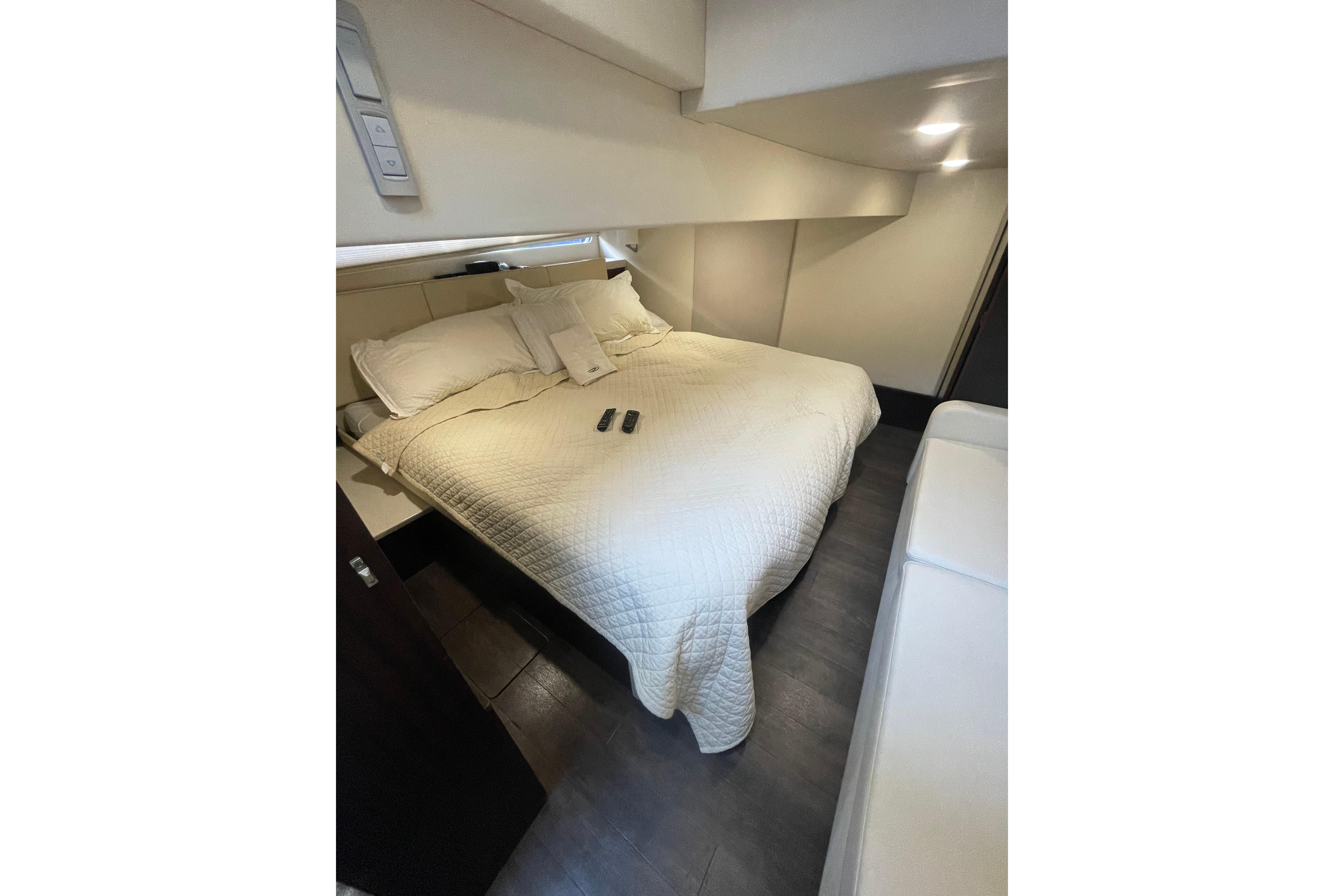 Luxurious bedroom interior of 2020 Regal 42 Grande Coupe yacht with cozy bedding.