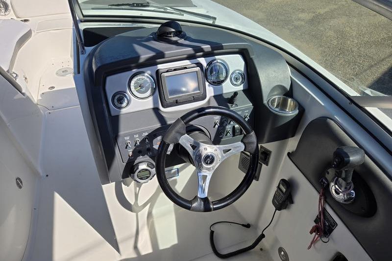 Cockpit of 2011 Sea Ray 300 Sundeck boat with steering wheel and control panel.