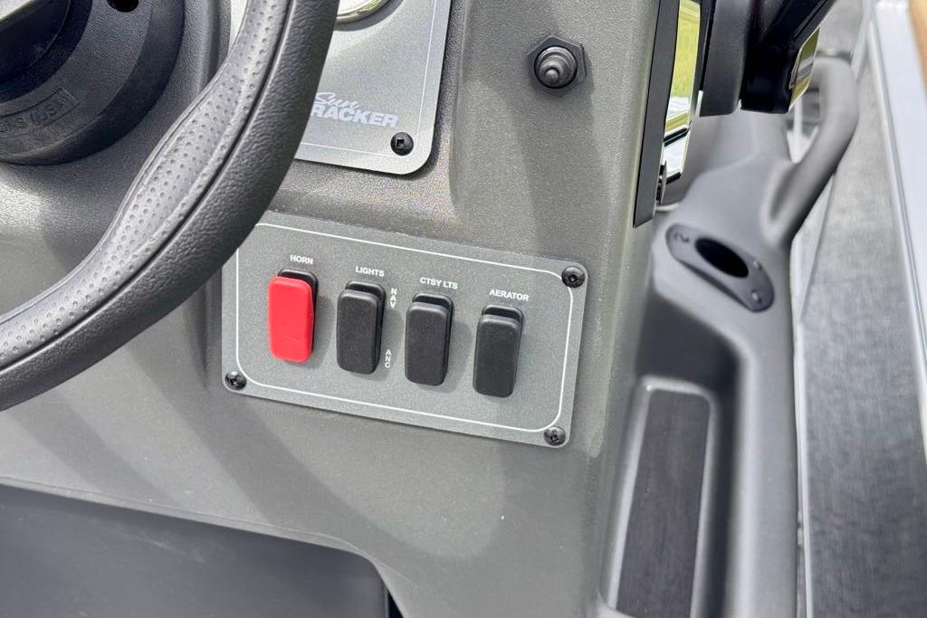 Control panel of 2026 Sun Tracker Bass Buggy 18 DLX with steering wheel and switches.
