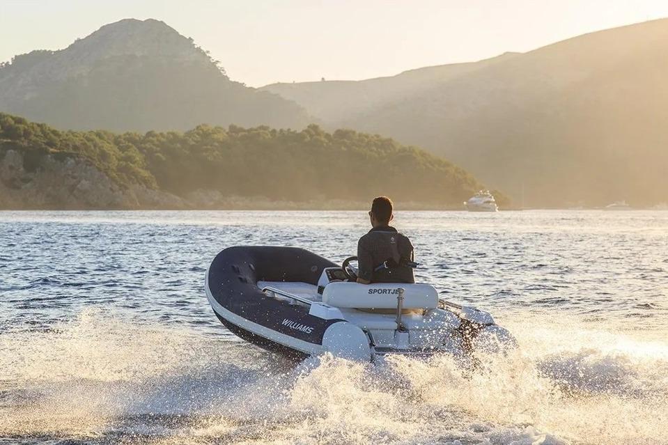 2021 Williams Sportjet 345 cruising on scenic water at sunset.