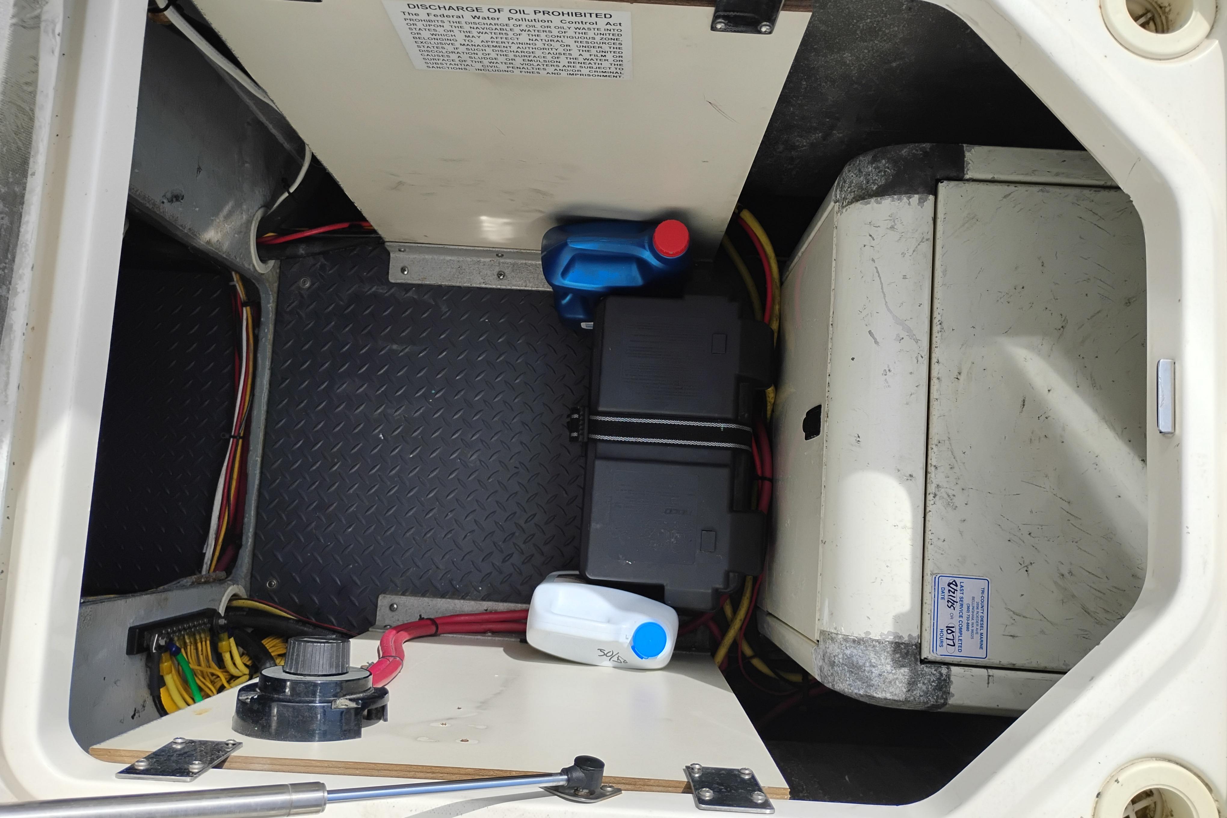 Engine compartment of a 2005 Silverton 38 Convertible boat with batteries and oil containers.