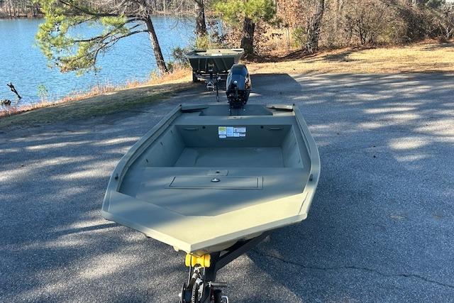 2026 Tracker Grizzly 1648 Utility boat on a trailer near a lake.