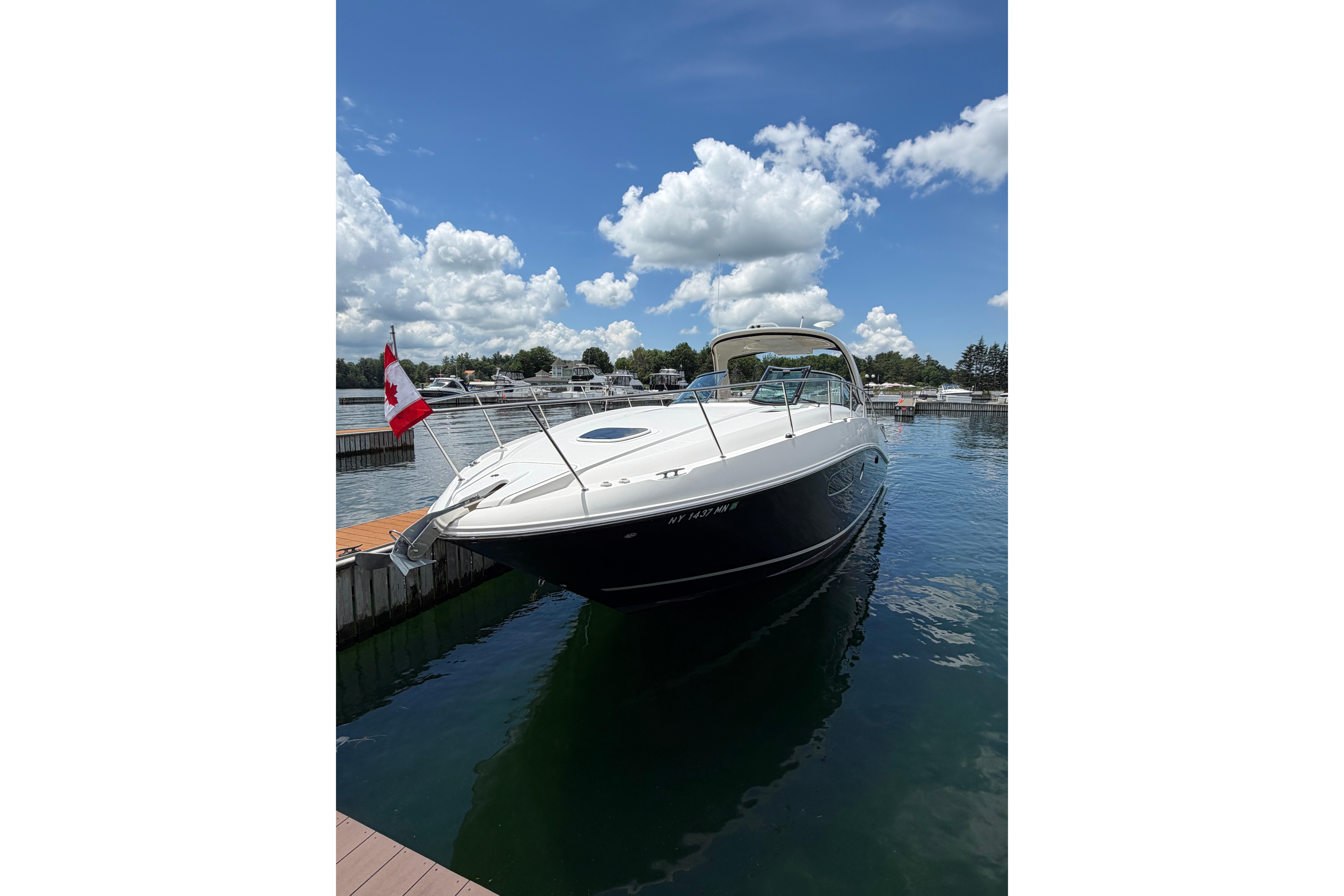 2012 Sea Ray Sundancer 370 docked on a sunny day with a Canadian flag.