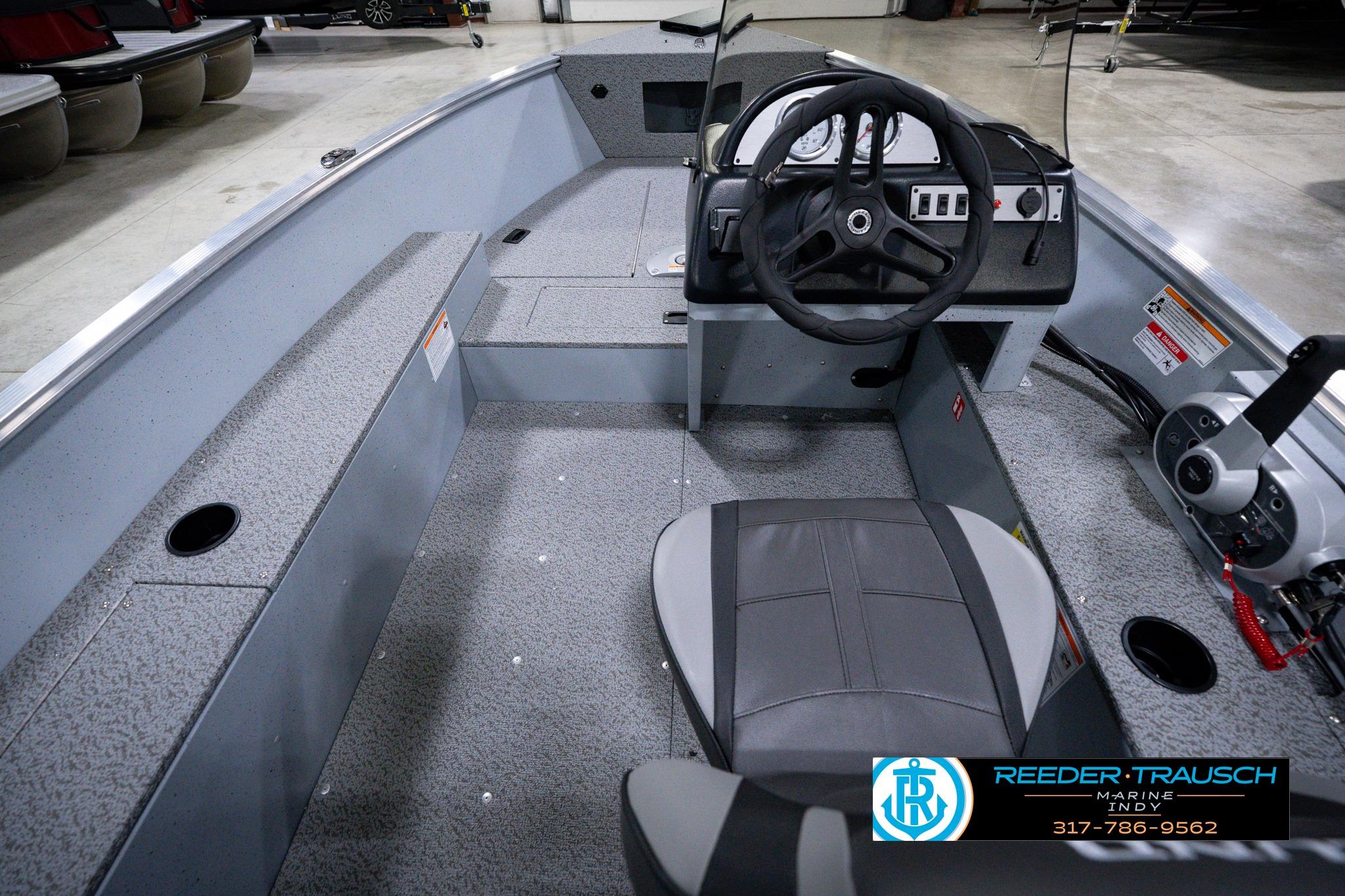 2026 Lund 1600 Fury SS boat interior with steering wheel and seating in showroom.