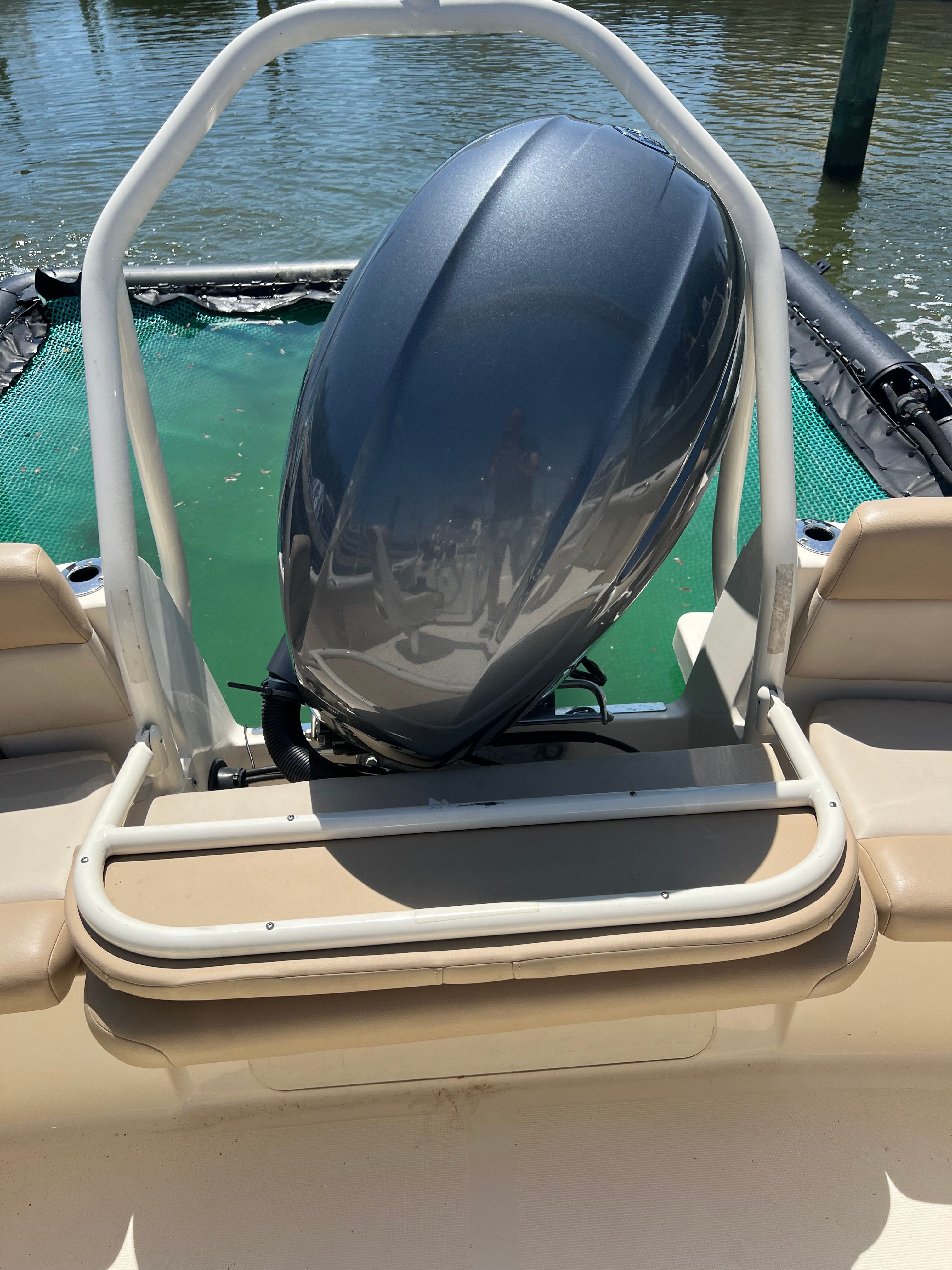 A 2021 Scout 195 Sport Dorado with an outboard motor at the stern, on calm water.