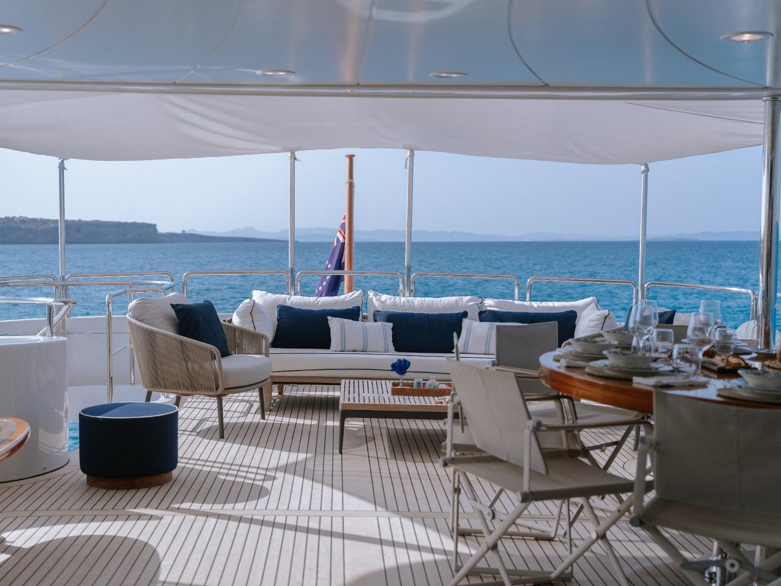 Luxurious deck of 2000 Benetti Classic 115 yacht with elegant seating and ocean view.