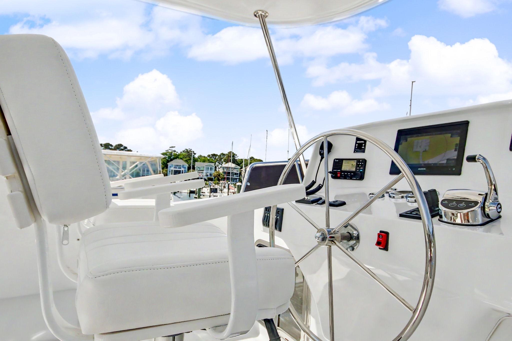 Pilothouse of 2022 North Pacific 45 yacht with steering wheel and navigation equipment.