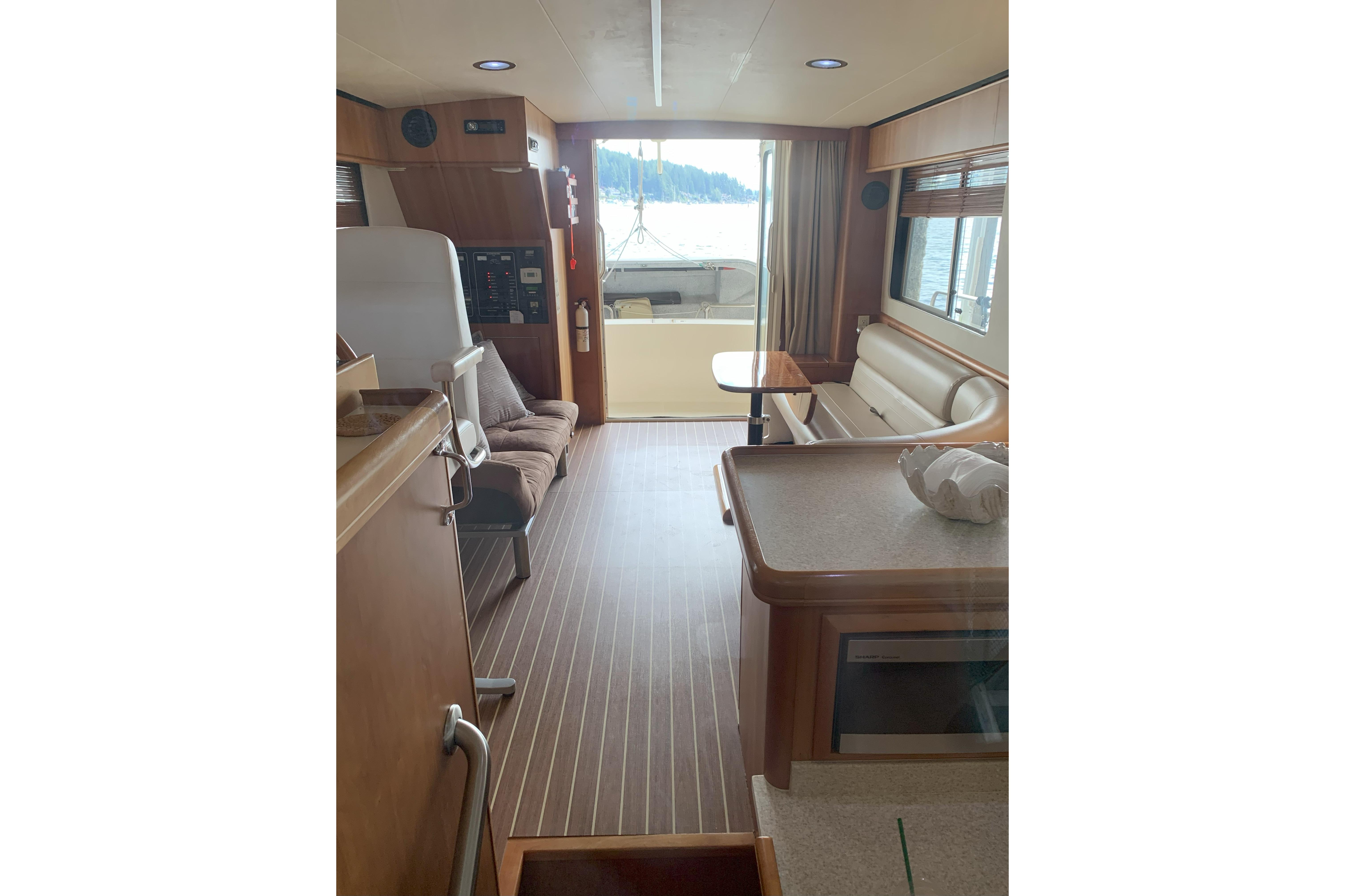 Interior of 2007 Mainship 34 Trawler with wood flooring and seating area.