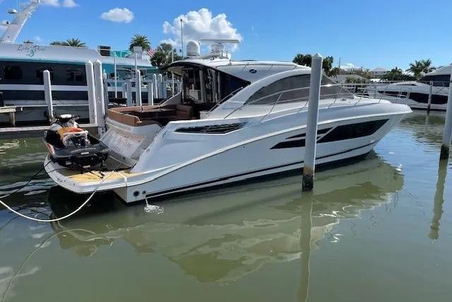 2016 Sea Ray Sundancer 510 yacht docked in a marina under a clear blue sky.