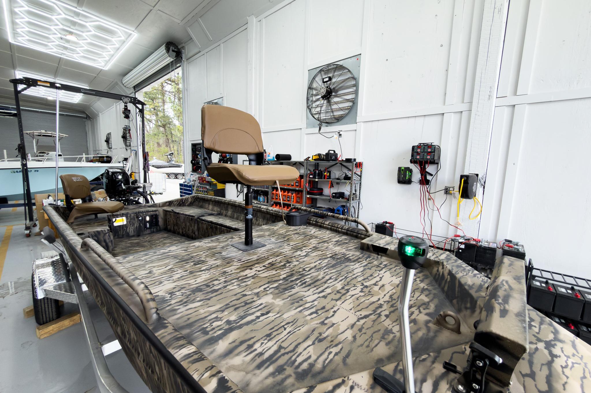 2026 Excel 1751 Viper F4 boat in a workshop, featuring camouflage design and modern seating.