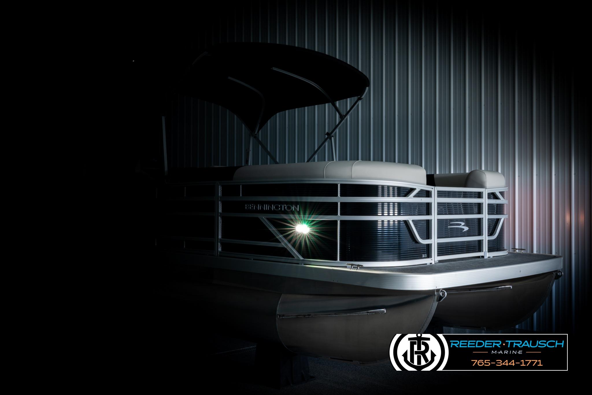 2026 Bennington SLSF pontoon boat in dimly lit showroom, highlighting sleek design.