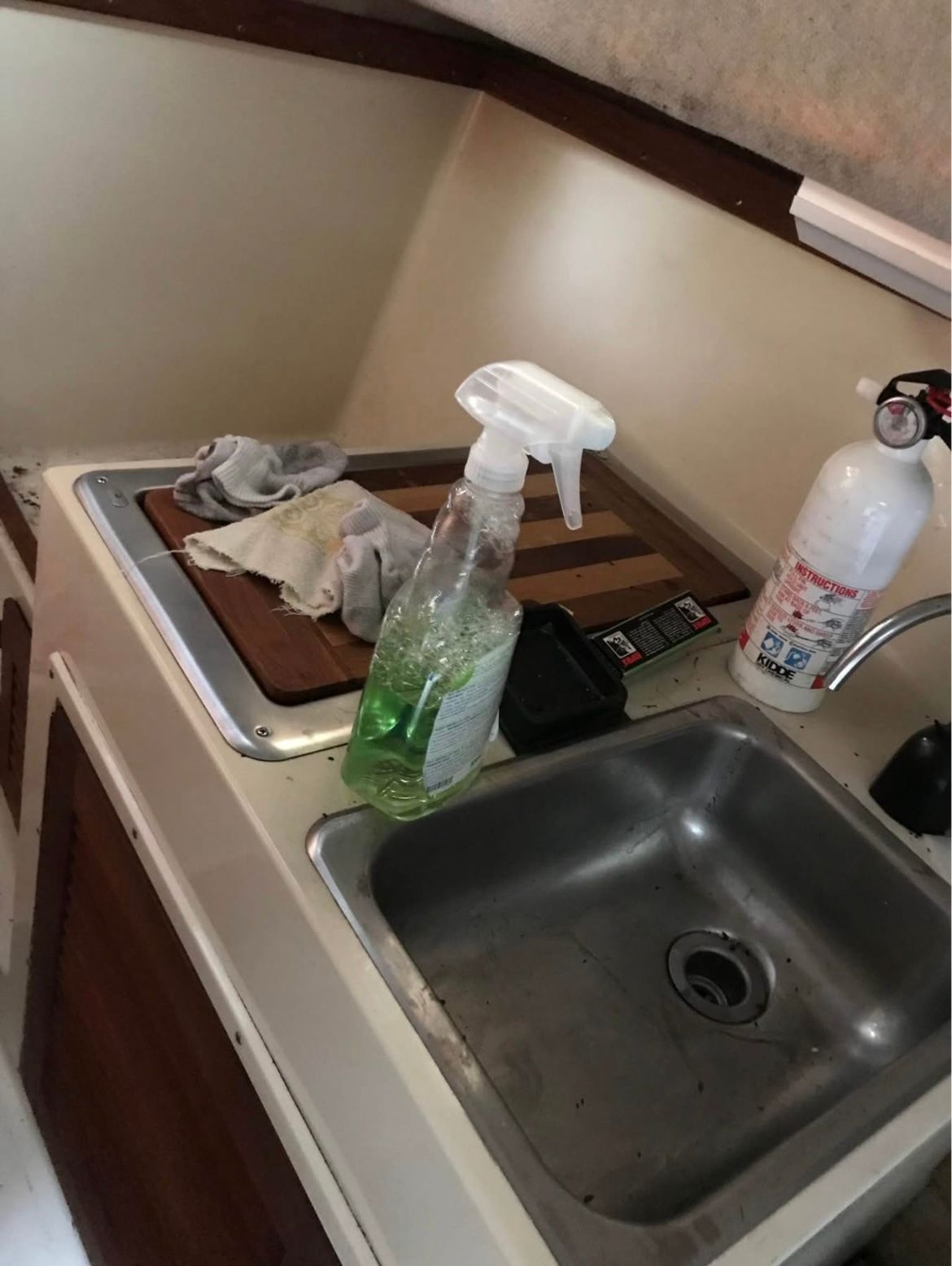 Galley area on a 1984 Tiara Yachts PURSUIT 2600 with sink and cleaning supplies.