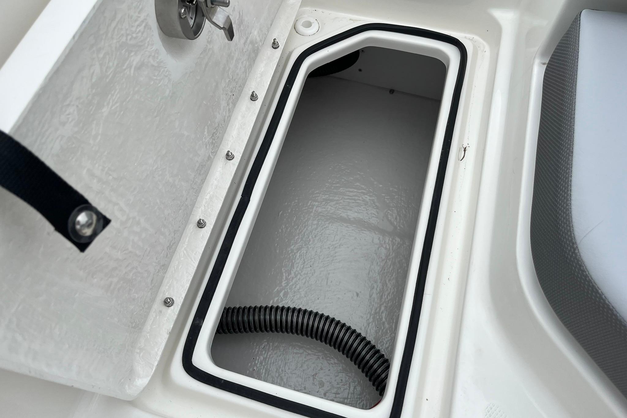 2026 Bayliner V20 boat storage compartment with open hatch and visible hose.