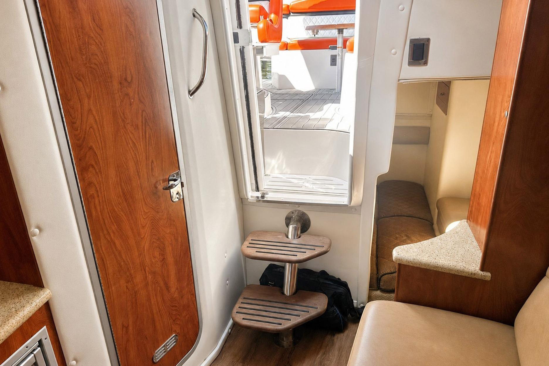 Interior view of 2012 Rinker 310 Express Cruiser LE, featuring wooden door and steps.