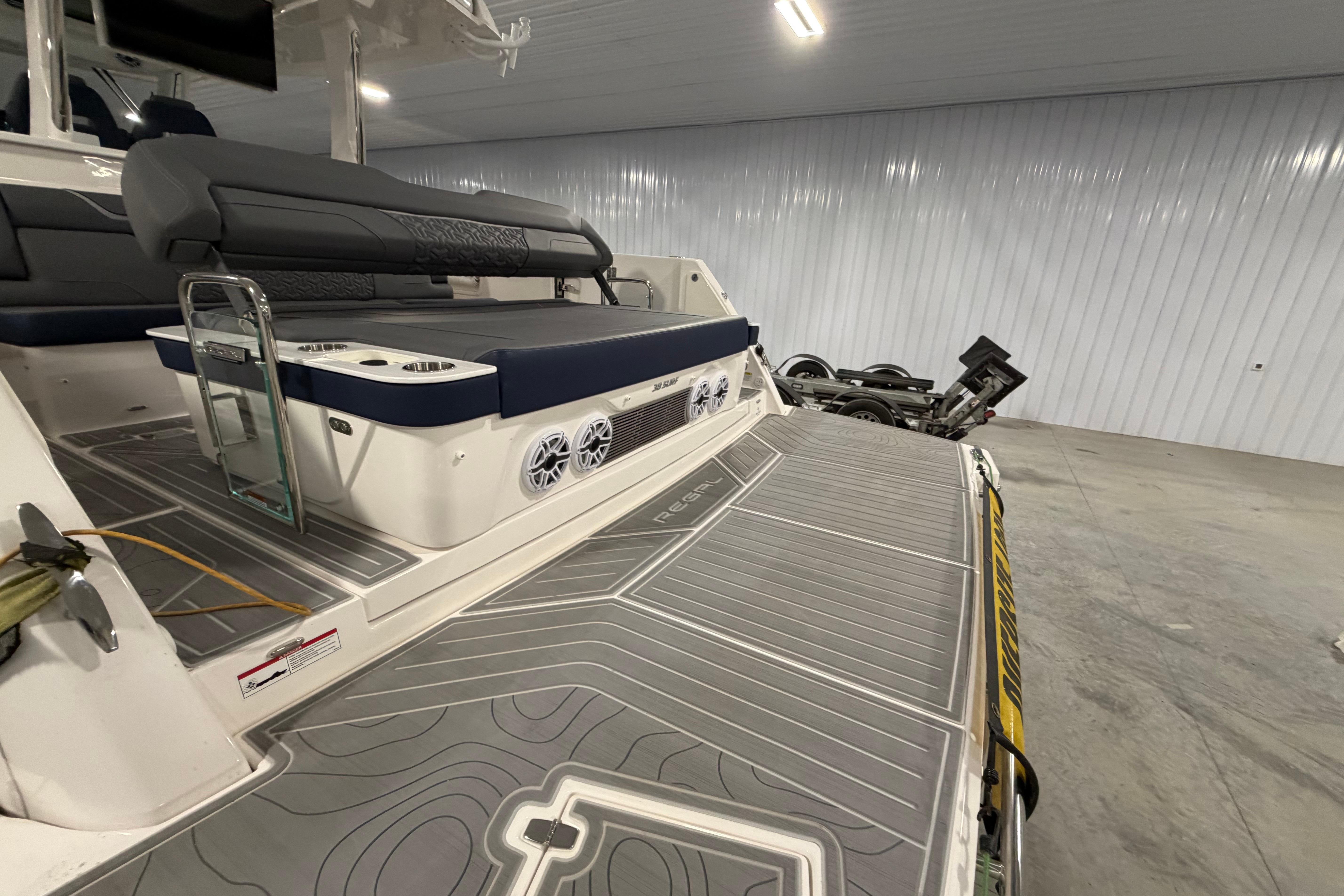 2027 Regal 38 Surf boat interior with seating and speakers in a garage setting.