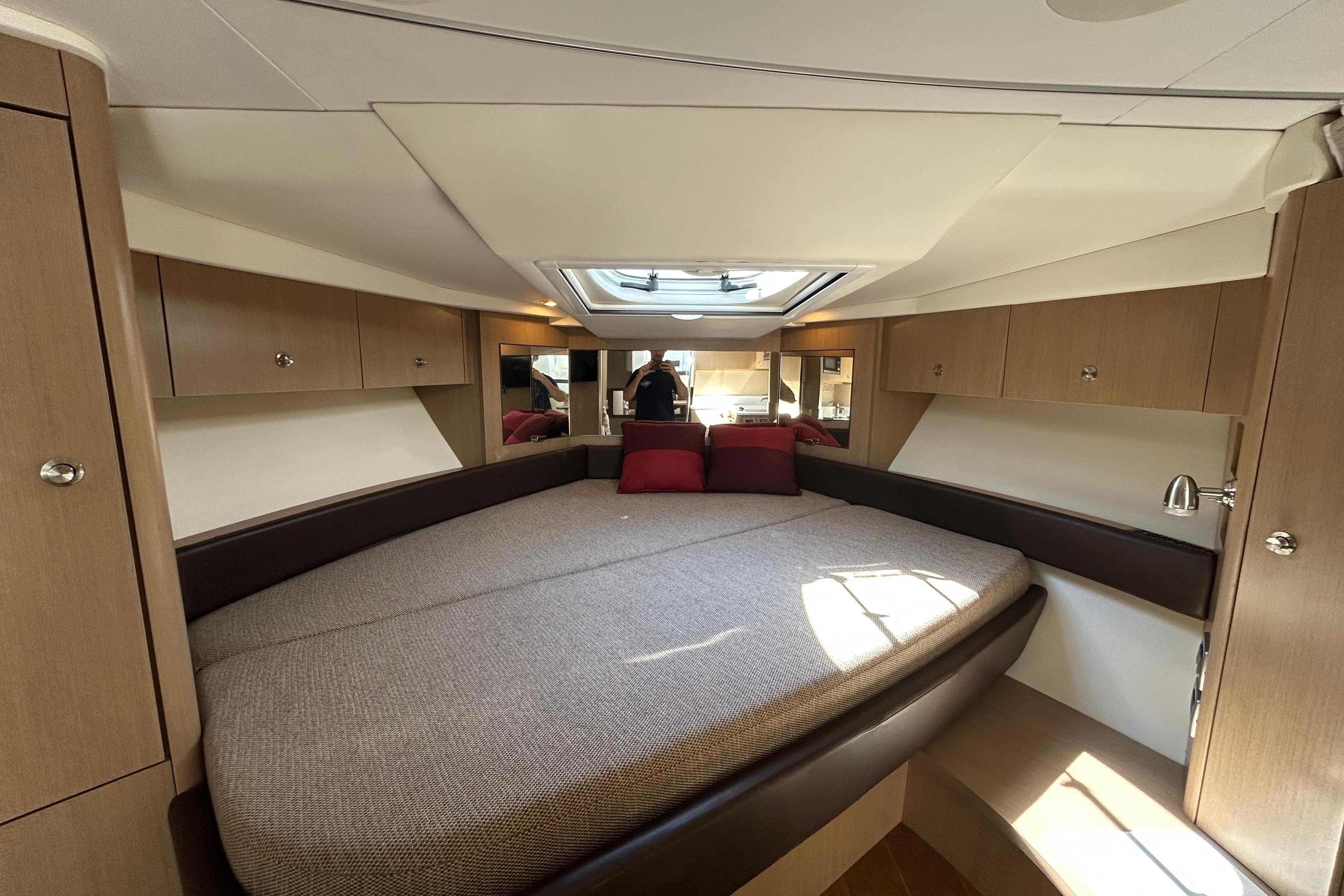 2019 Sea Ray Sundancer 350 cabin interior with bed, skylight, and wooden cabinetry.