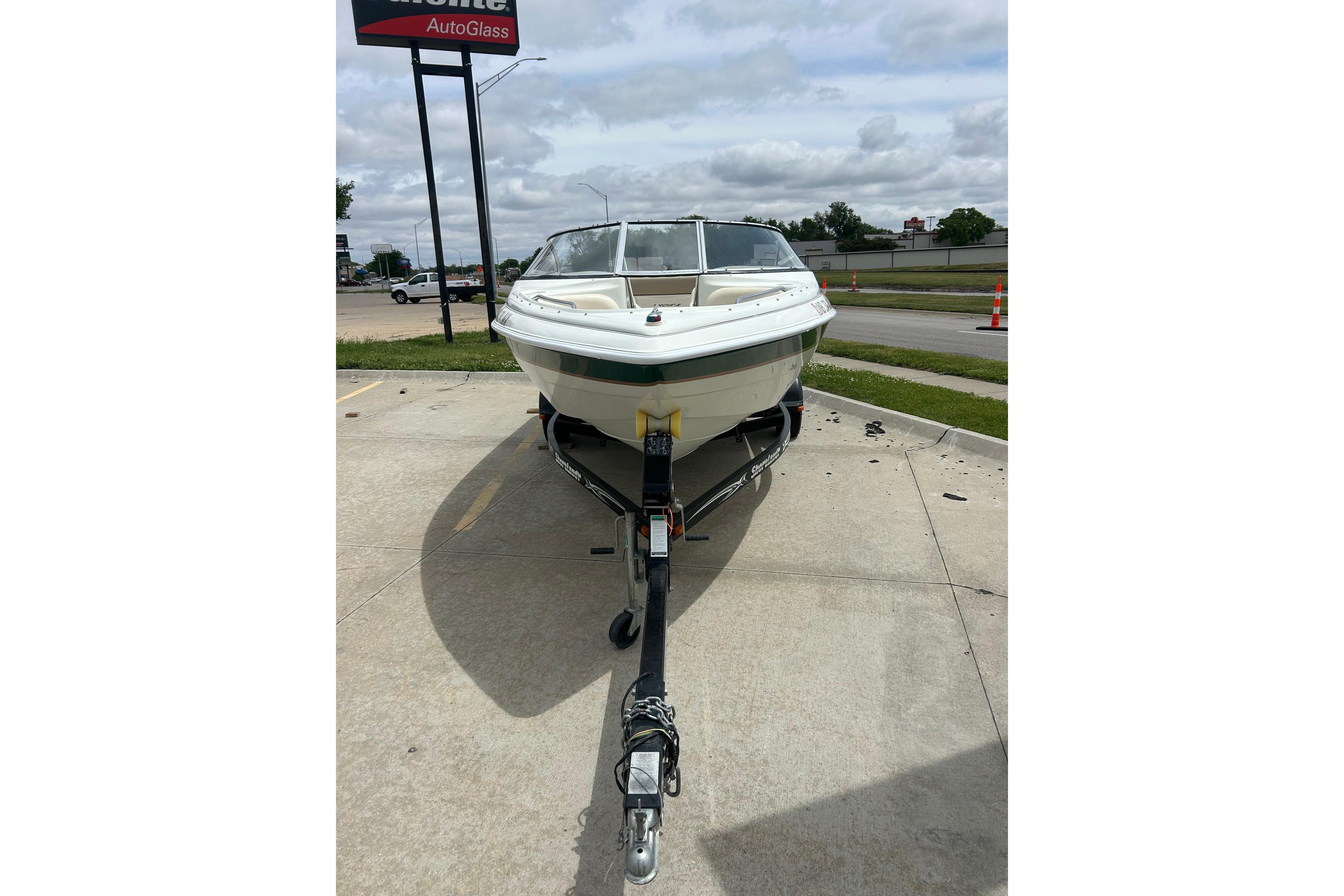 2000 Starcraft 1810 boat on trailer in parking lot.