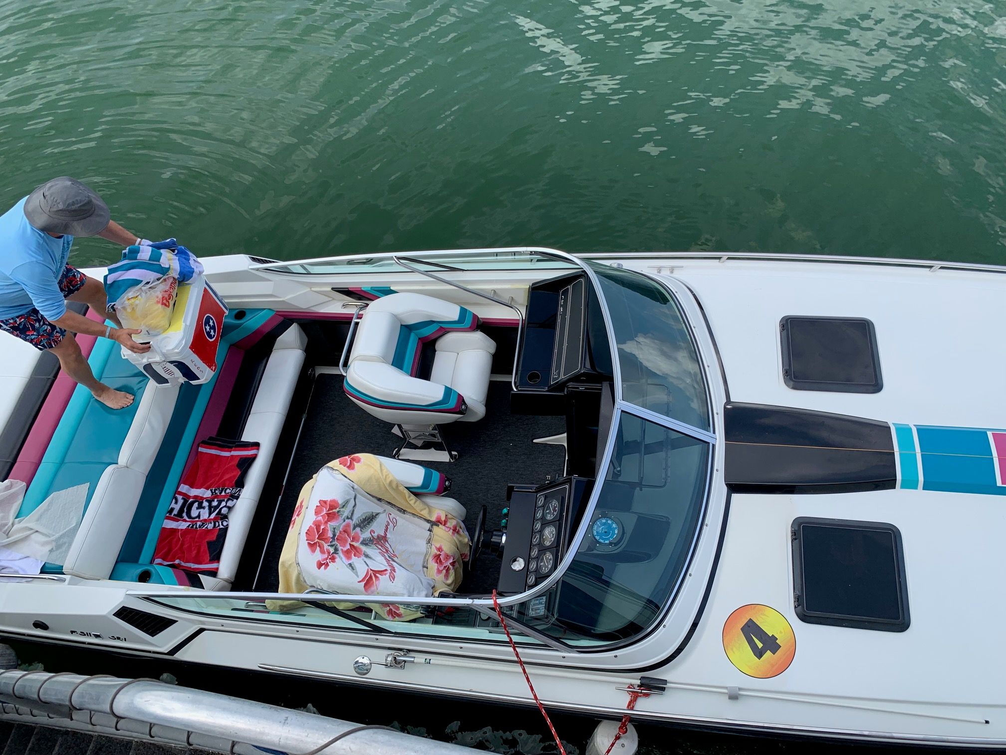 A 1988 Formula 311 SR1 boat on the water with colorful seats and a person on board.
