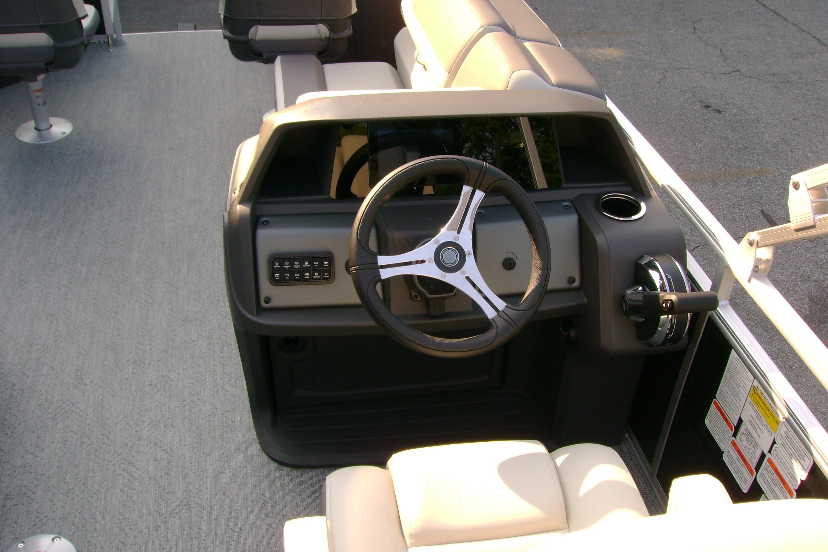 2026 Sun Tracker Fishin' Barge 20 DLX helm with steering wheel and controls.