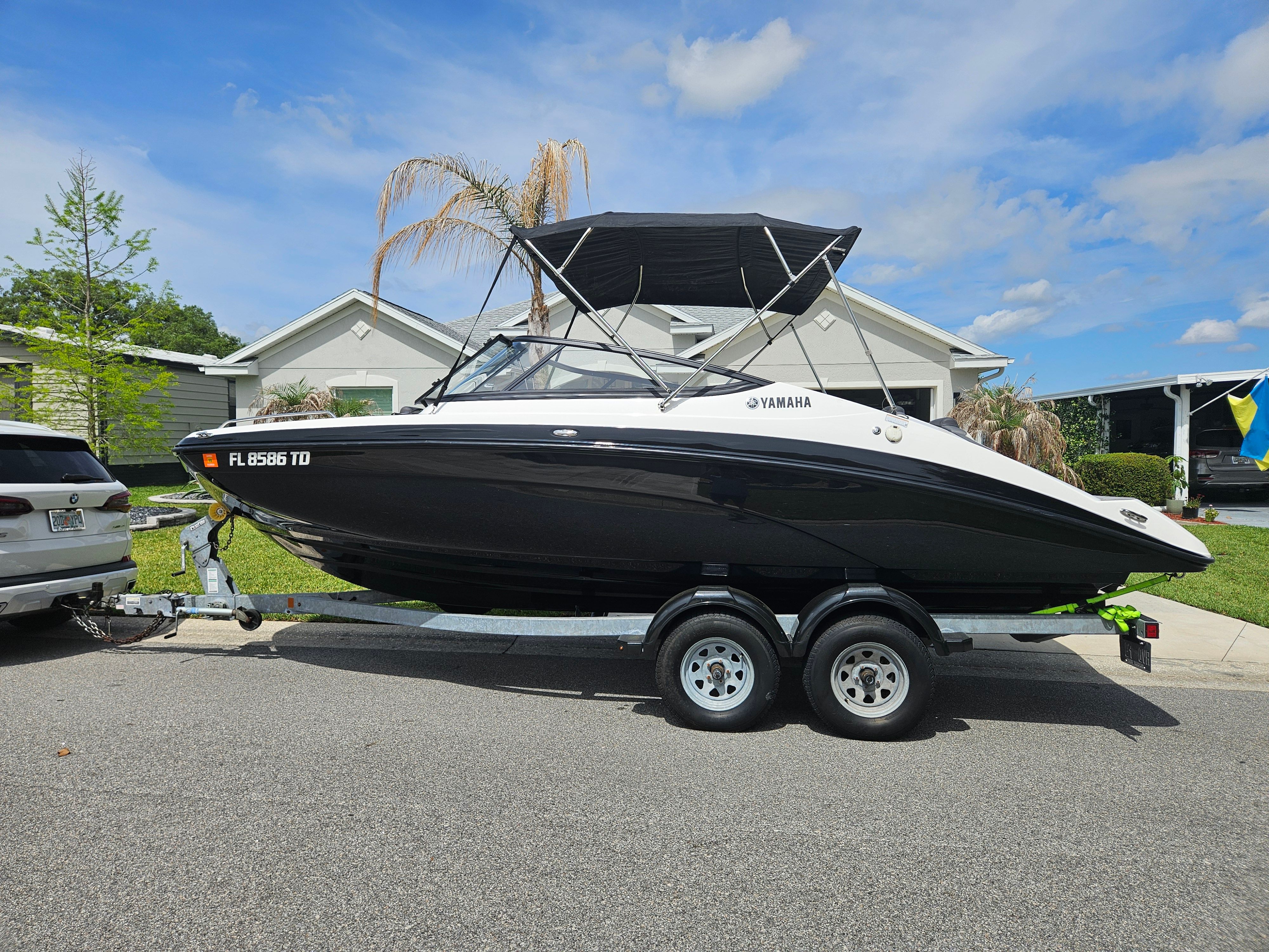 2022 Yamaha SX210 boat on trailer parked in front of house.