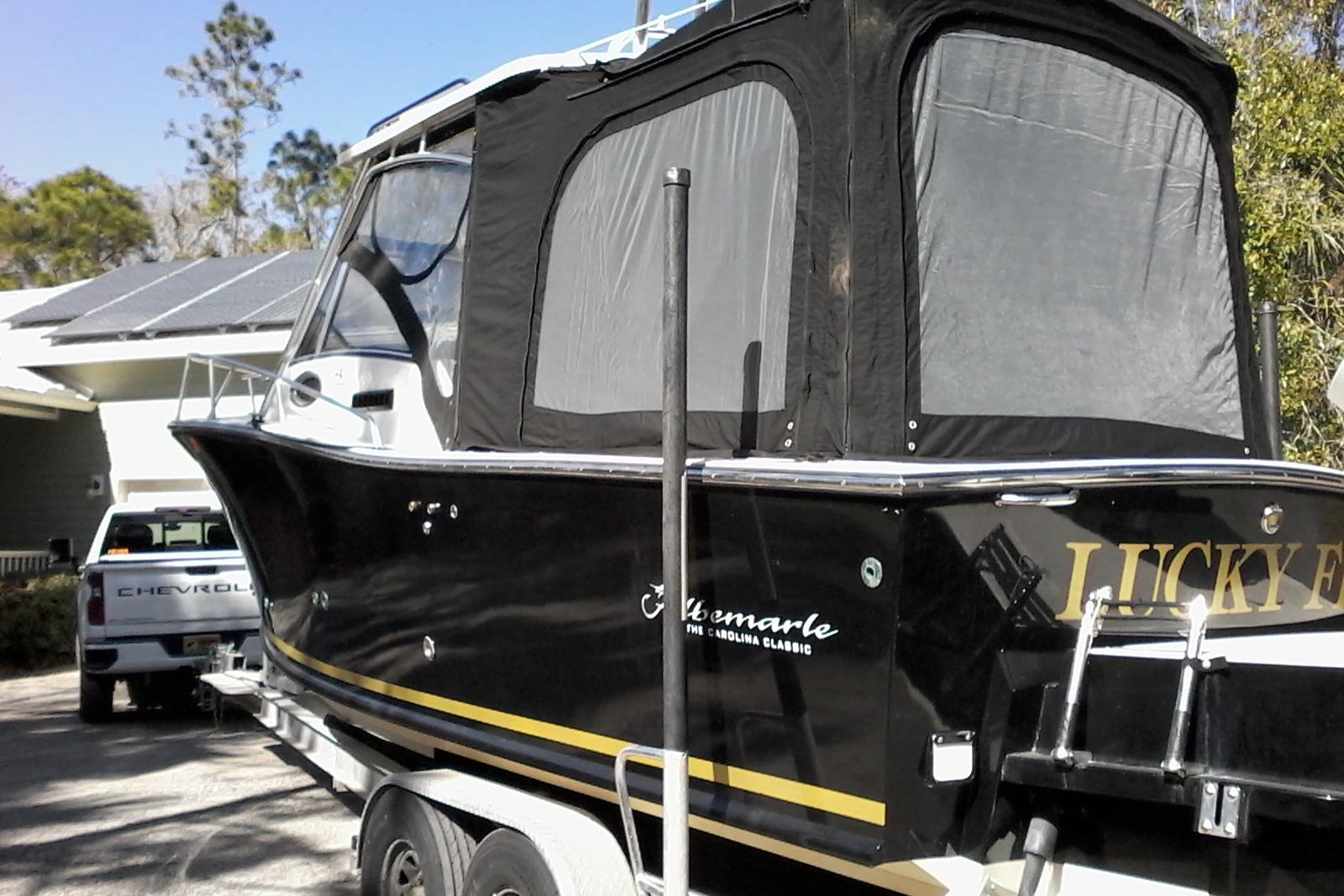 2002 Albemarle 265 Express Fisherman boat on trailer, parked near a Chevrolet truck.