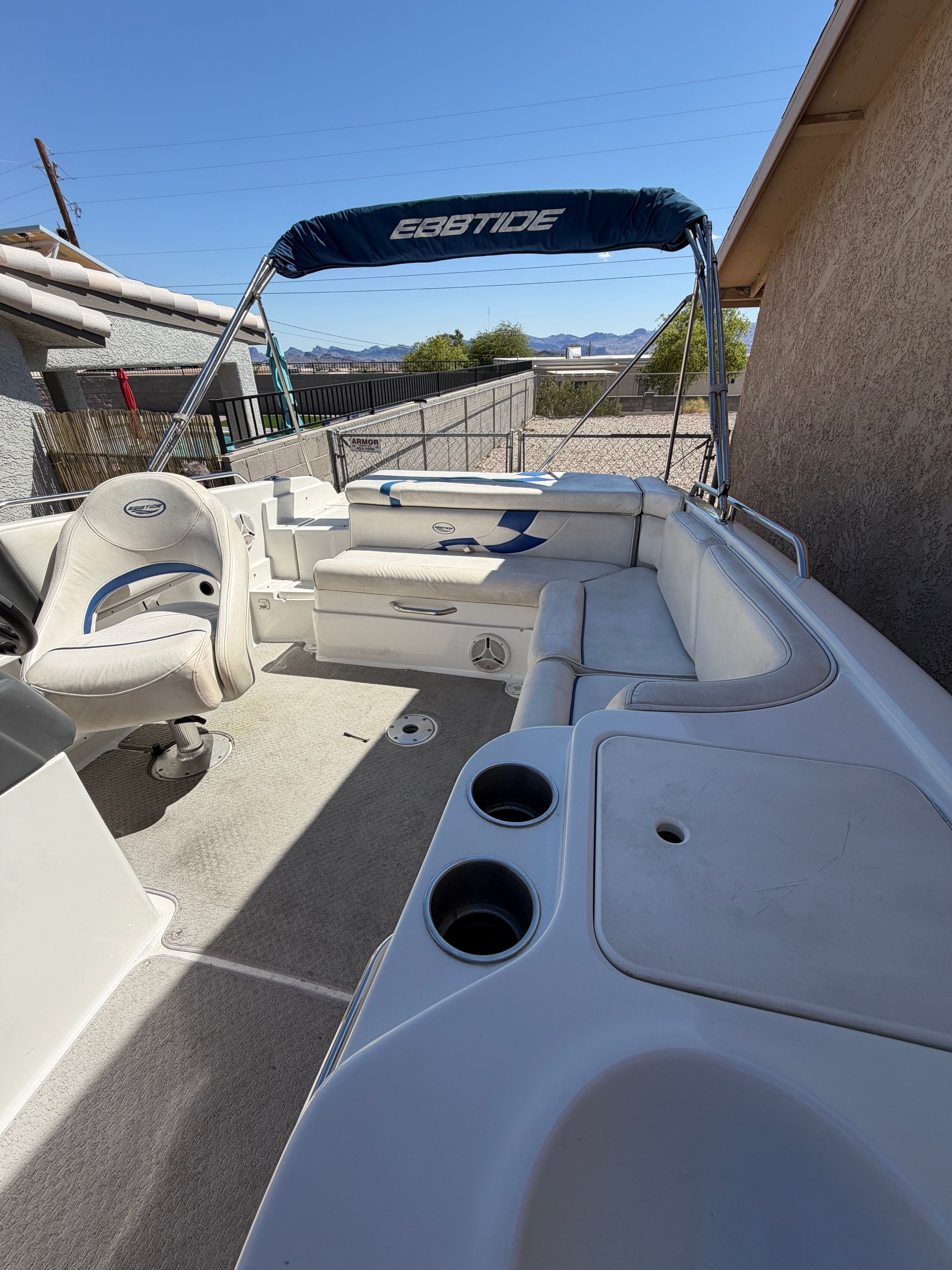 A 2008 Ebbtide 2100 SS Fun Cruiser is parked on a dry spot next to a building.