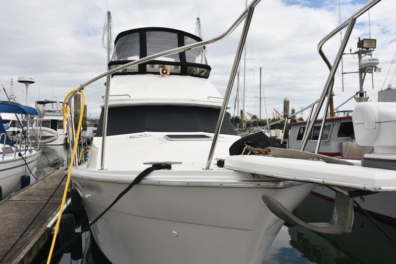 1990 Bayliner 3288 Motoryacht docked at marina, front view with clear sky.