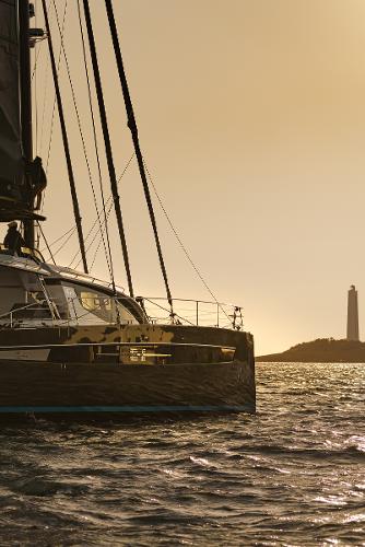 Luxury Privilege Signature 650 yacht sailing at sunset near a lighthouse, 2025 model.