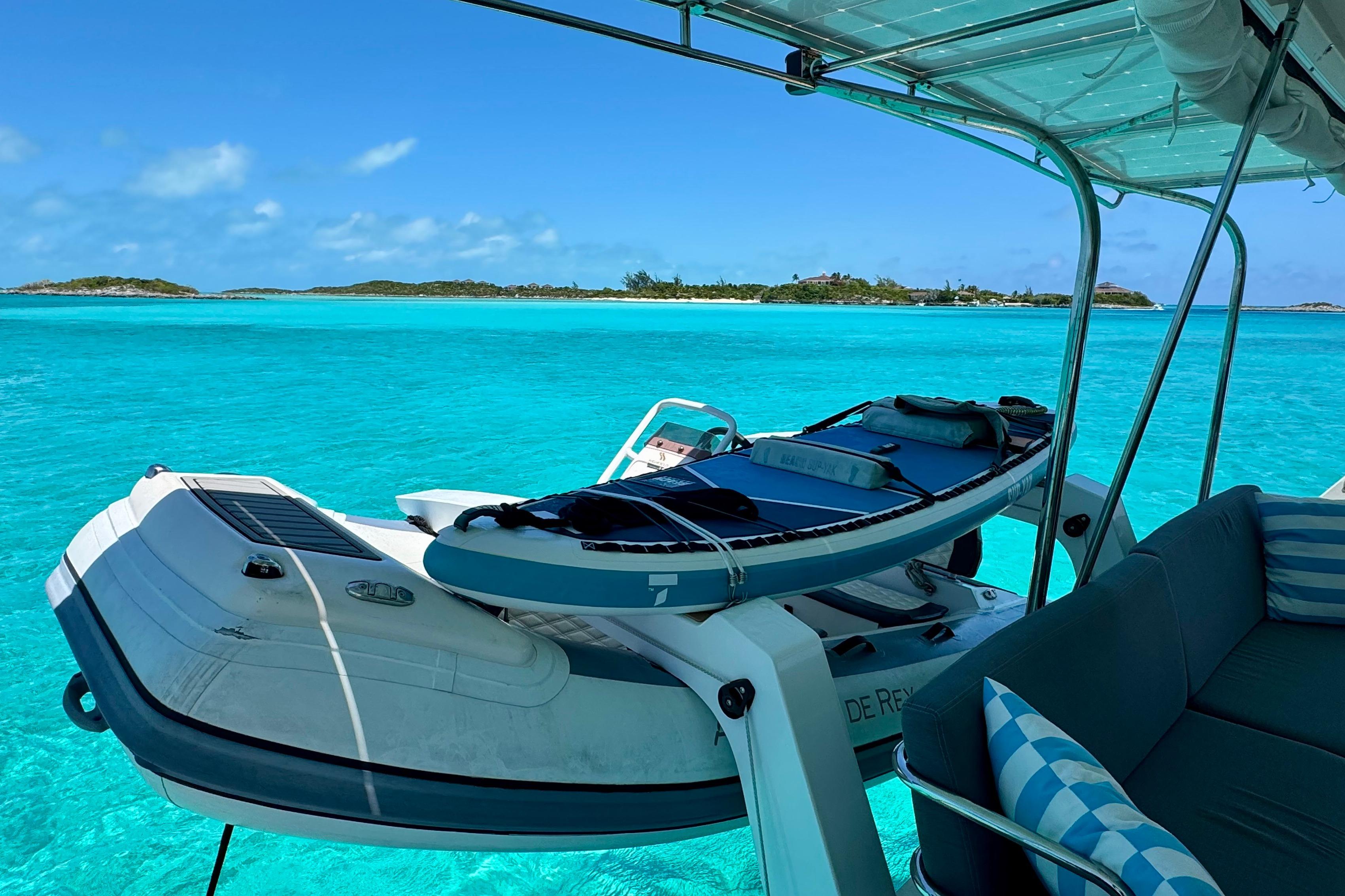 Fountaine Pajot Saona 47 catamaran with paddleboard, turquoise waters, and island view.
