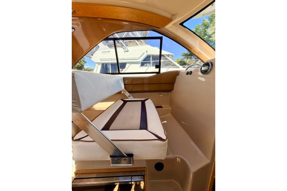Interior of 2017 Cutwater C-242 Coupe boat with cushioned seating and window view.
