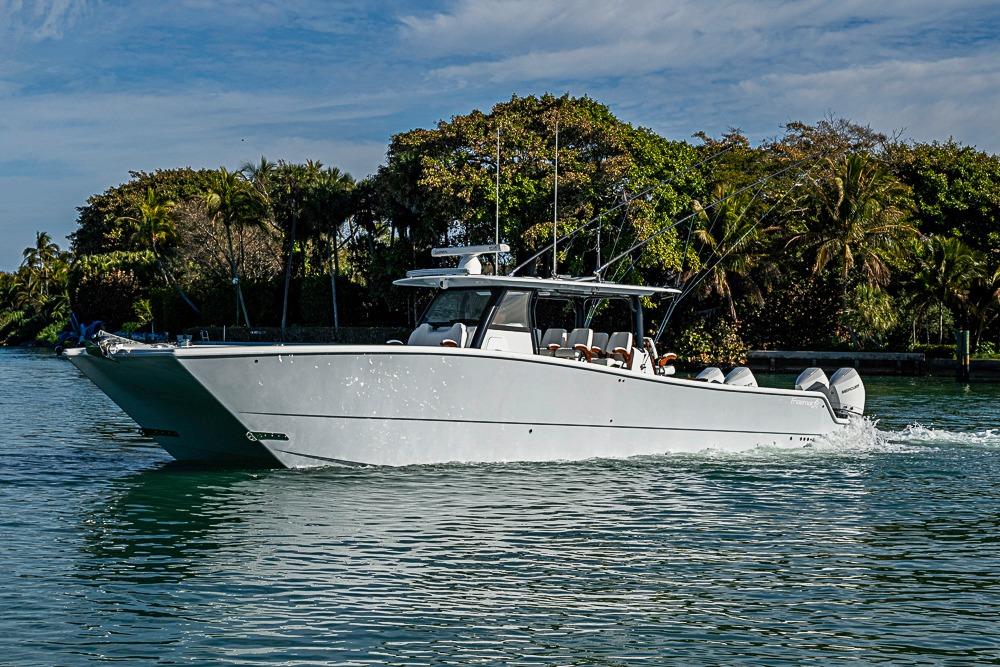 2023 Freeman 47 boat cruising on a scenic waterway with lush greenery.