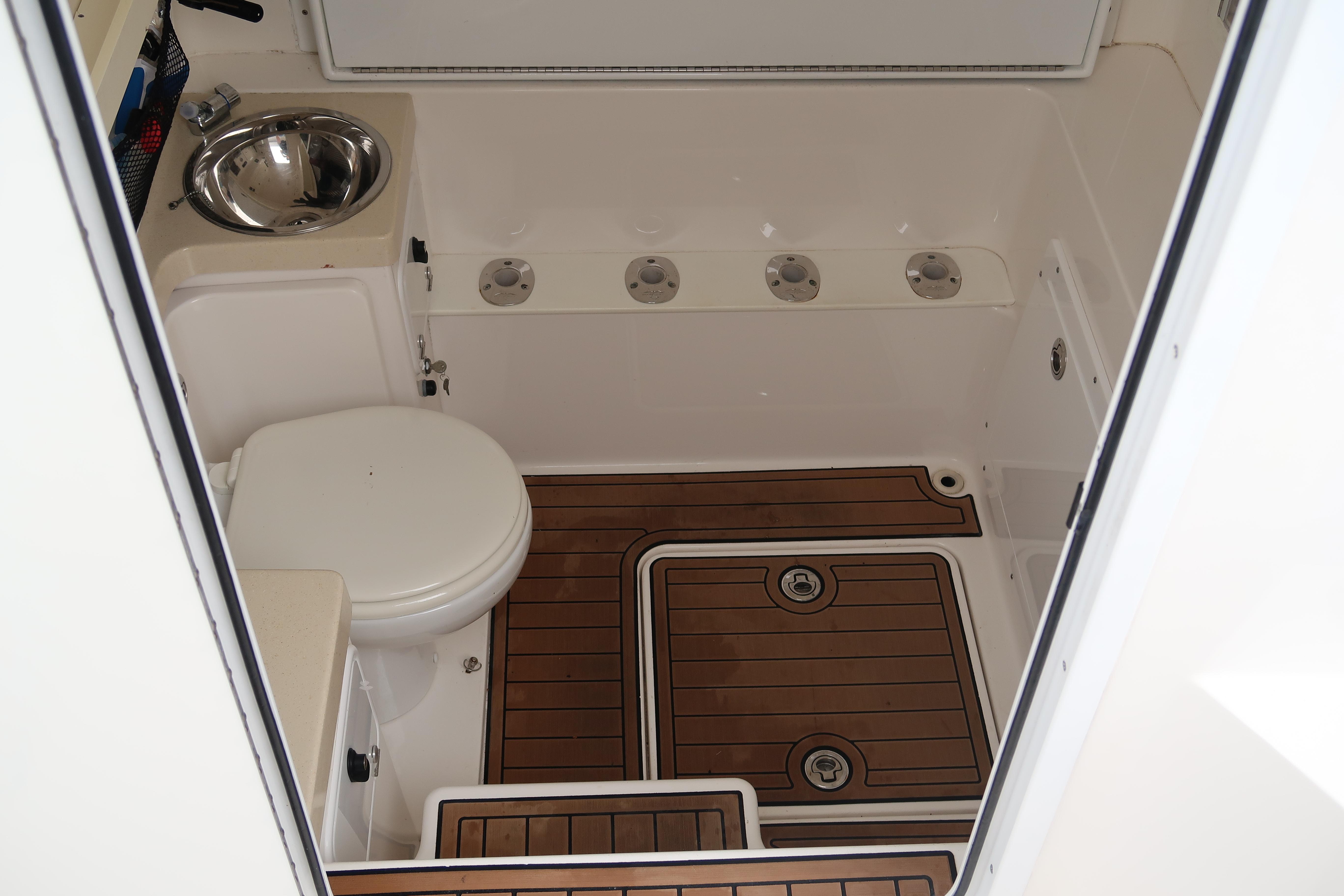 2016 Invincible 42 Open Fisherman boat bathroom with wooden flooring and stainless steel sink.