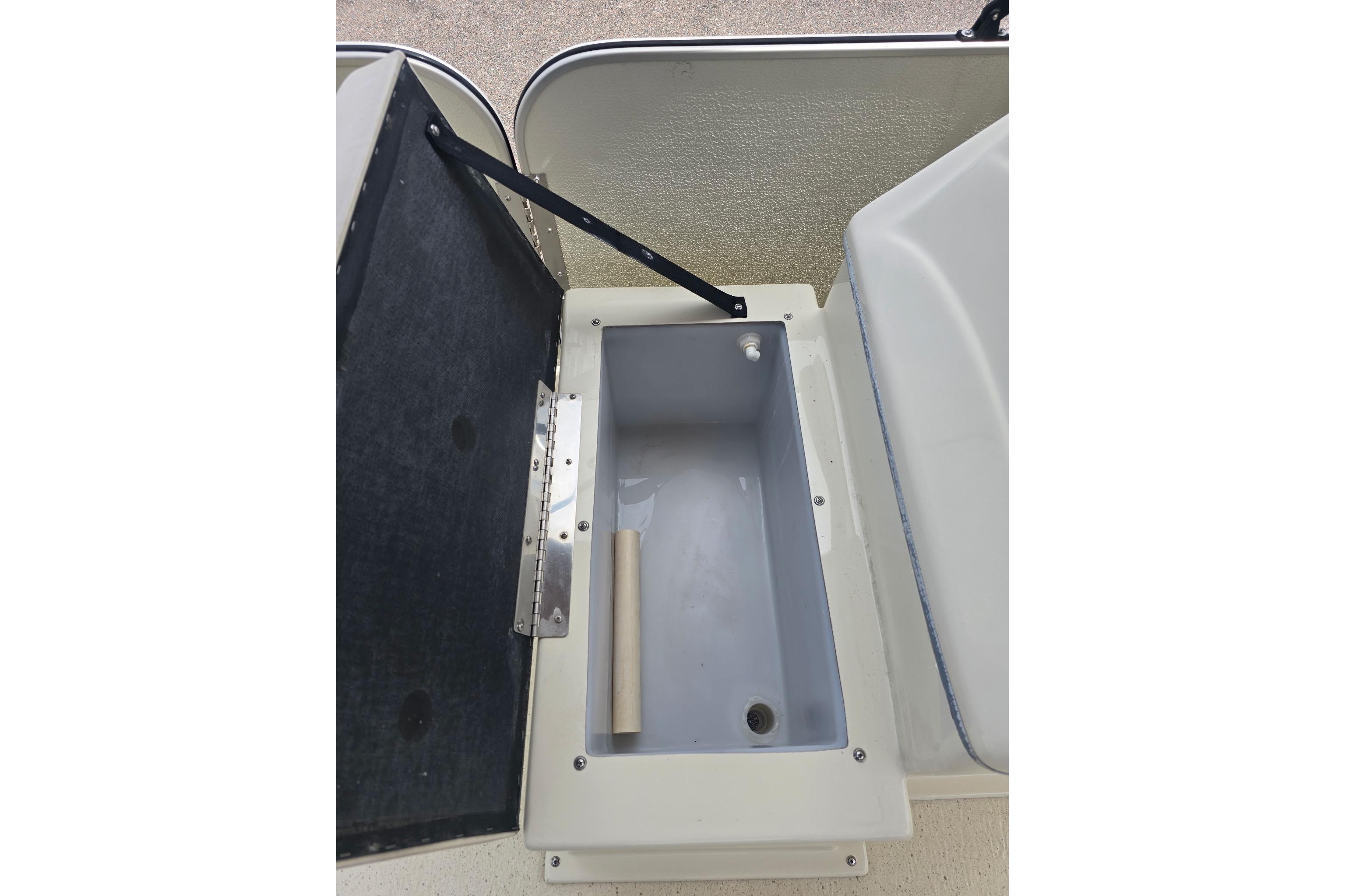 Open storage compartment in a 2022 Sunray 14' Sunfisher boat, featuring a hinged lid.
