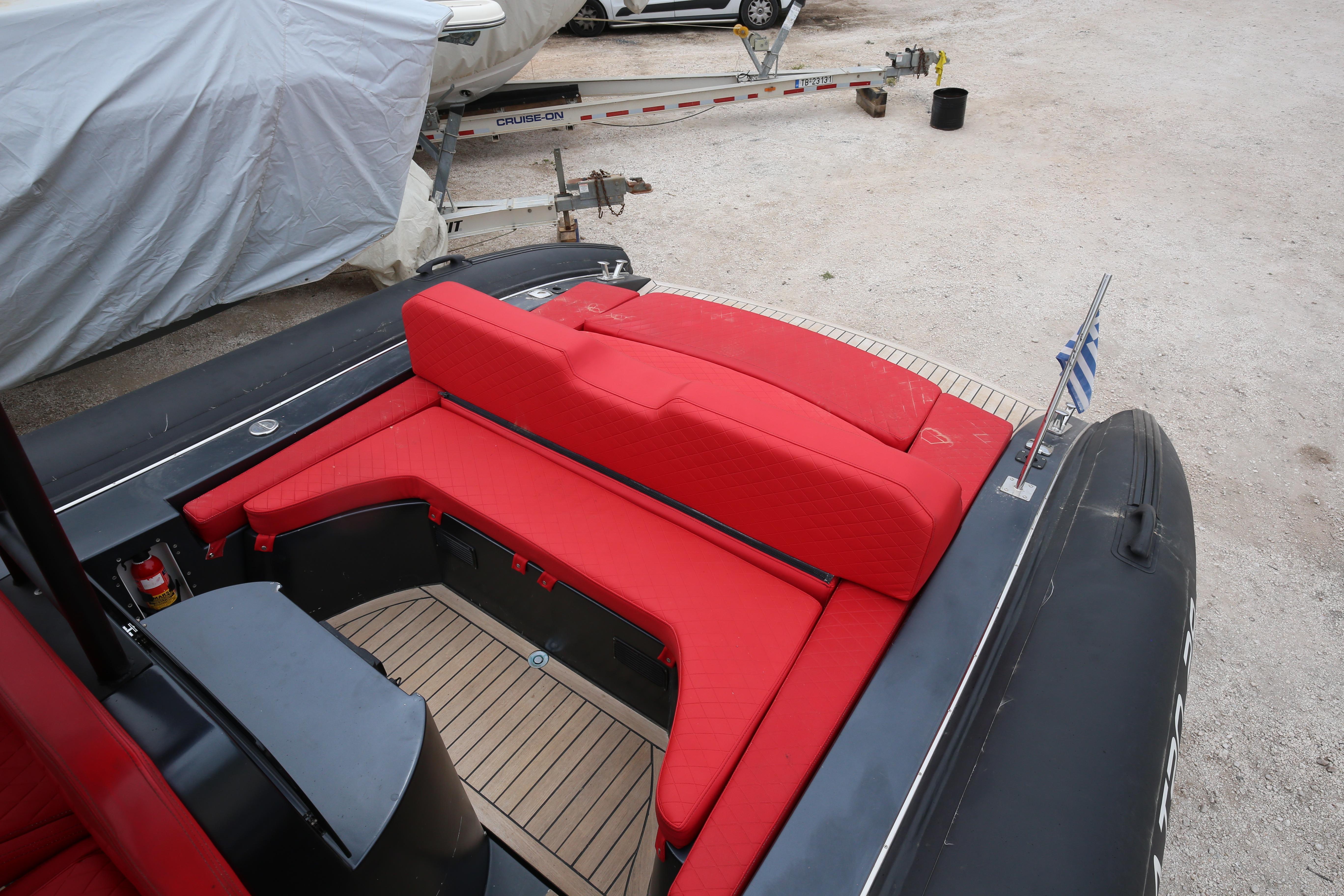 Red seating area on a 2019 Albatro 28 boat, docked with a visible flag.