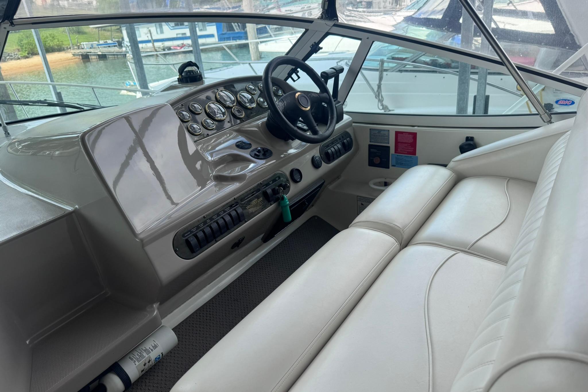 2002 Cruisers Yachts 3275 Express cockpit with steering wheel and control panel.